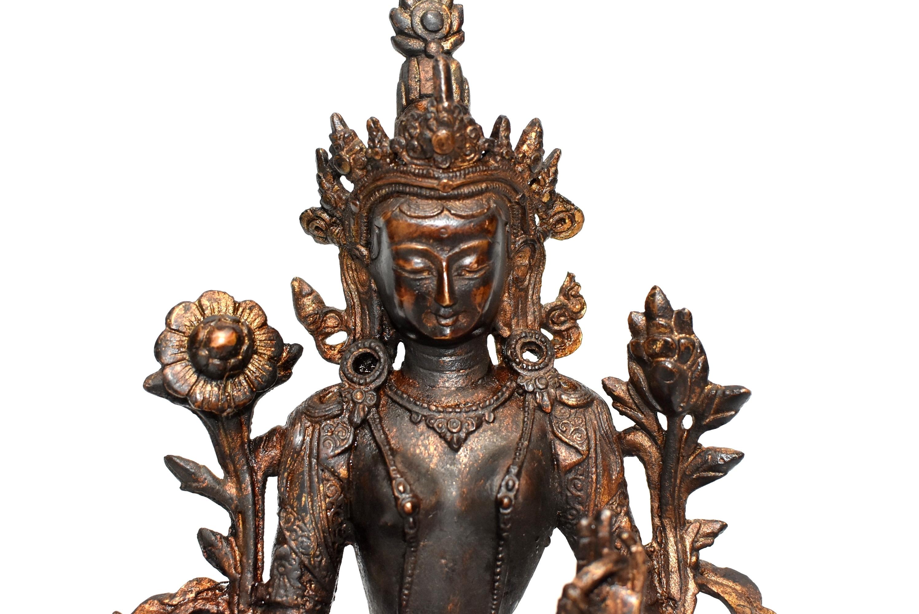 A beautiful seated figure of Avalokiteshvara, commonly known as the Green Tara. The bodhisattva is shown seated in lalitasana with the right foot supported on a lotus stem that projects from the front of the double-lotus base. The hands are held in