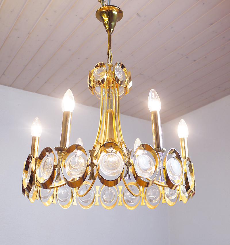 Elegant chandelier with a gold-plated brass frame and Swarovski crystals. These lamps have an incomparable unique character. A touch of luxury fills the room. Manufactured by Lobmeyr, Vienna, Austria in the 1960s. 

Design: J. & L. Lobmeyr.