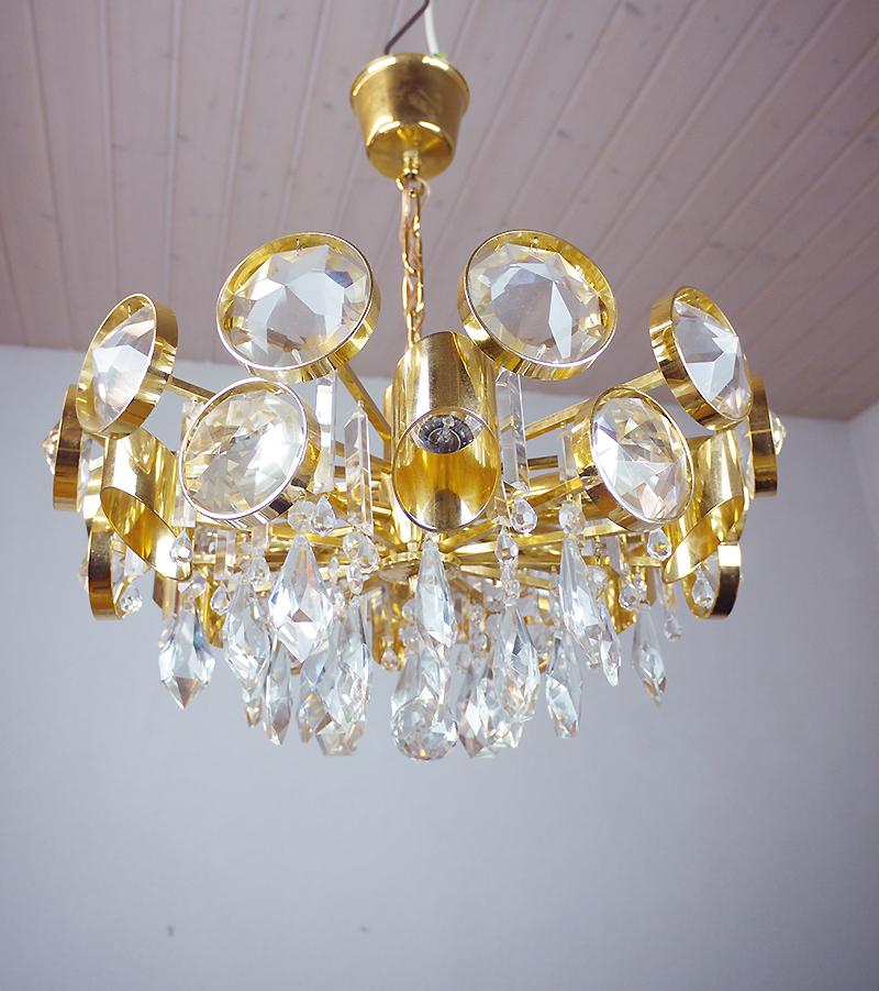 Elegant chandelier with a gold-plated brass frame and Swarovski crystals. These lamps have an incomparable unique character. A touch of luxury fills the room. Manufactured by Lobmeyr, Vienna, Austria in the 1960s. 

Design: J. & L. Lobmeyr.