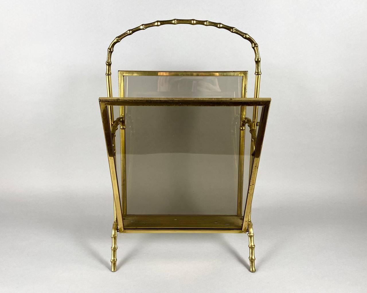 This vintage magazine rack made by famous French designer Maison Baguès in a faux bamboo bronze structure and smoked glass panels. Made in France, circa 1960s.

The magazine rack takes up little space, and its size allows you to place all popular