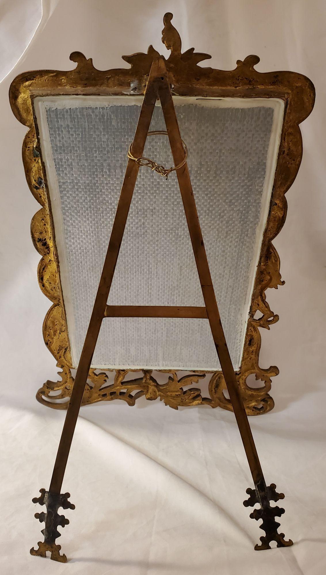 Antique Gilt French Mirror Frame. Wonderful motif of angels in a fight holding spheres. Good vs Evil. This item measures approx. - 18.5 inches high x 12.5 inches wide. when the stand is put and open the item measures approx. 12.5 inches deep. When