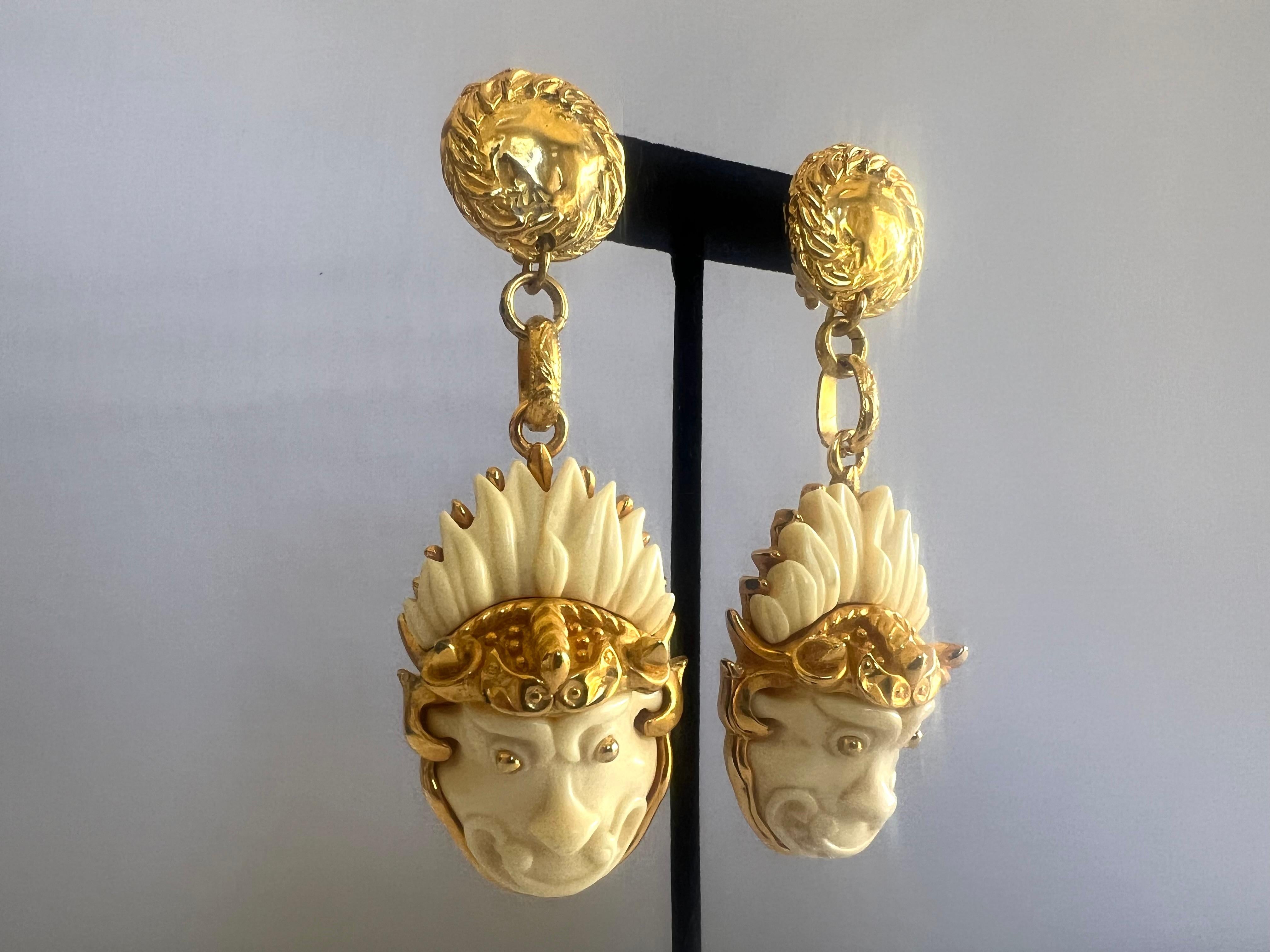 Unusual vintage clip-on dangle earrings, gilt metal, and heavily carved white galalith depicting dragons. Made in France.