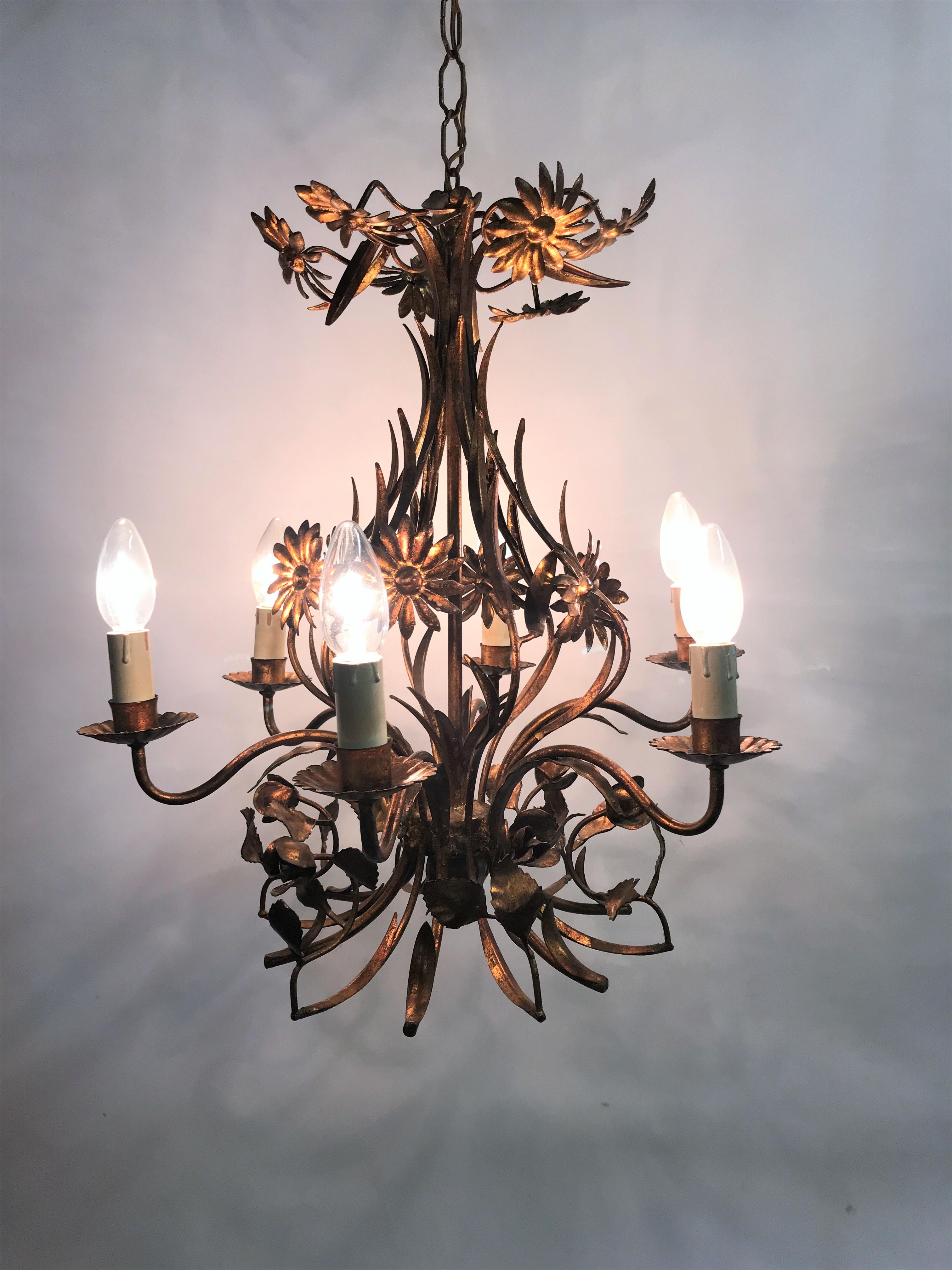 midcentury 5 lightpoint candle chandelier.

This gilt metal flower chandelier was made in Italy and is beautifully decorated with flowers and leaves giving it a very charming look.

1950s - Italy

Tested and ready to use with regular E14