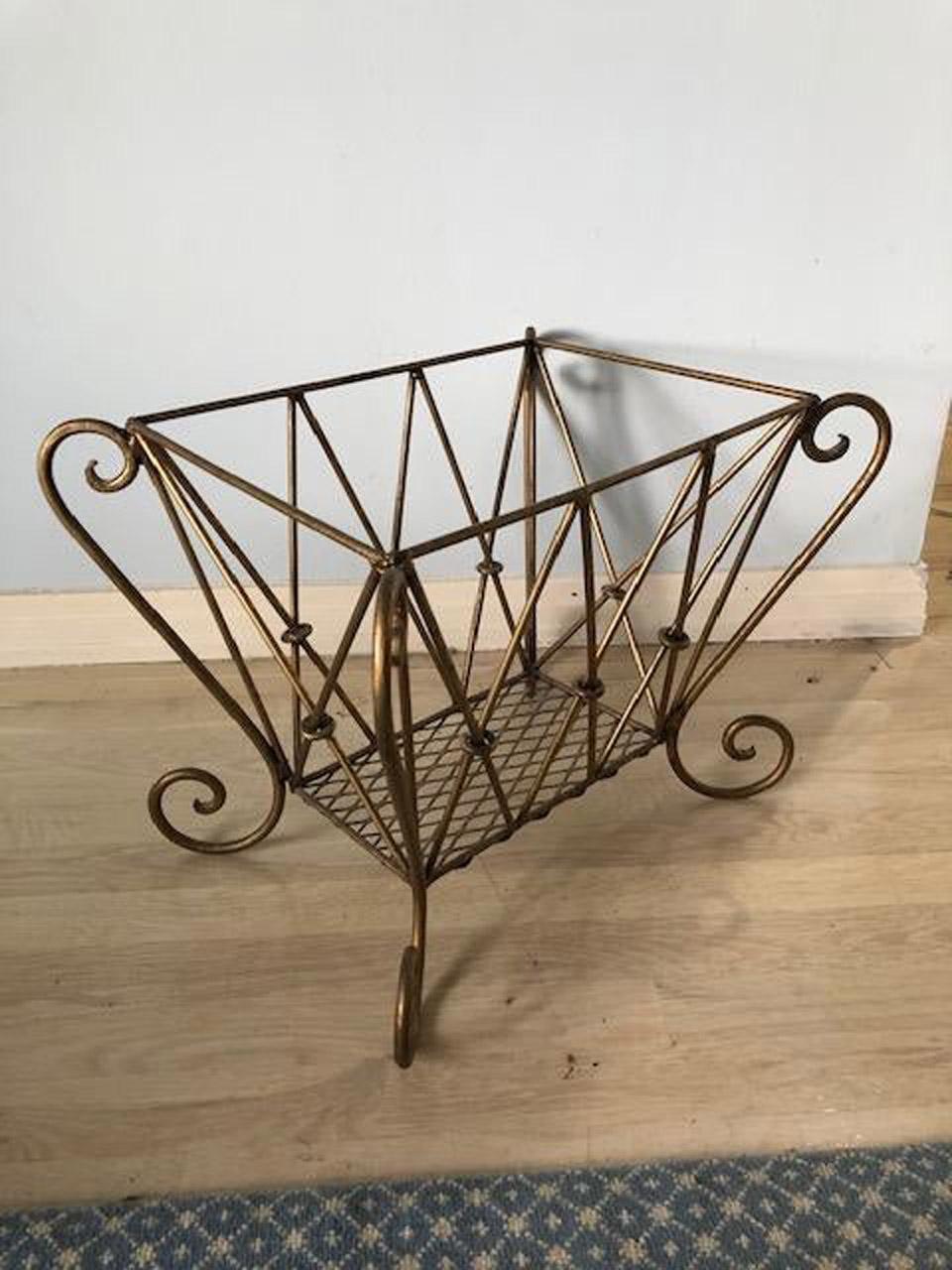 The vintage Hollywood Regency style magazine rack is made of gilt metal designed with a flare. Add a liner and it could become a log/kindling basket. Potted plant stand?