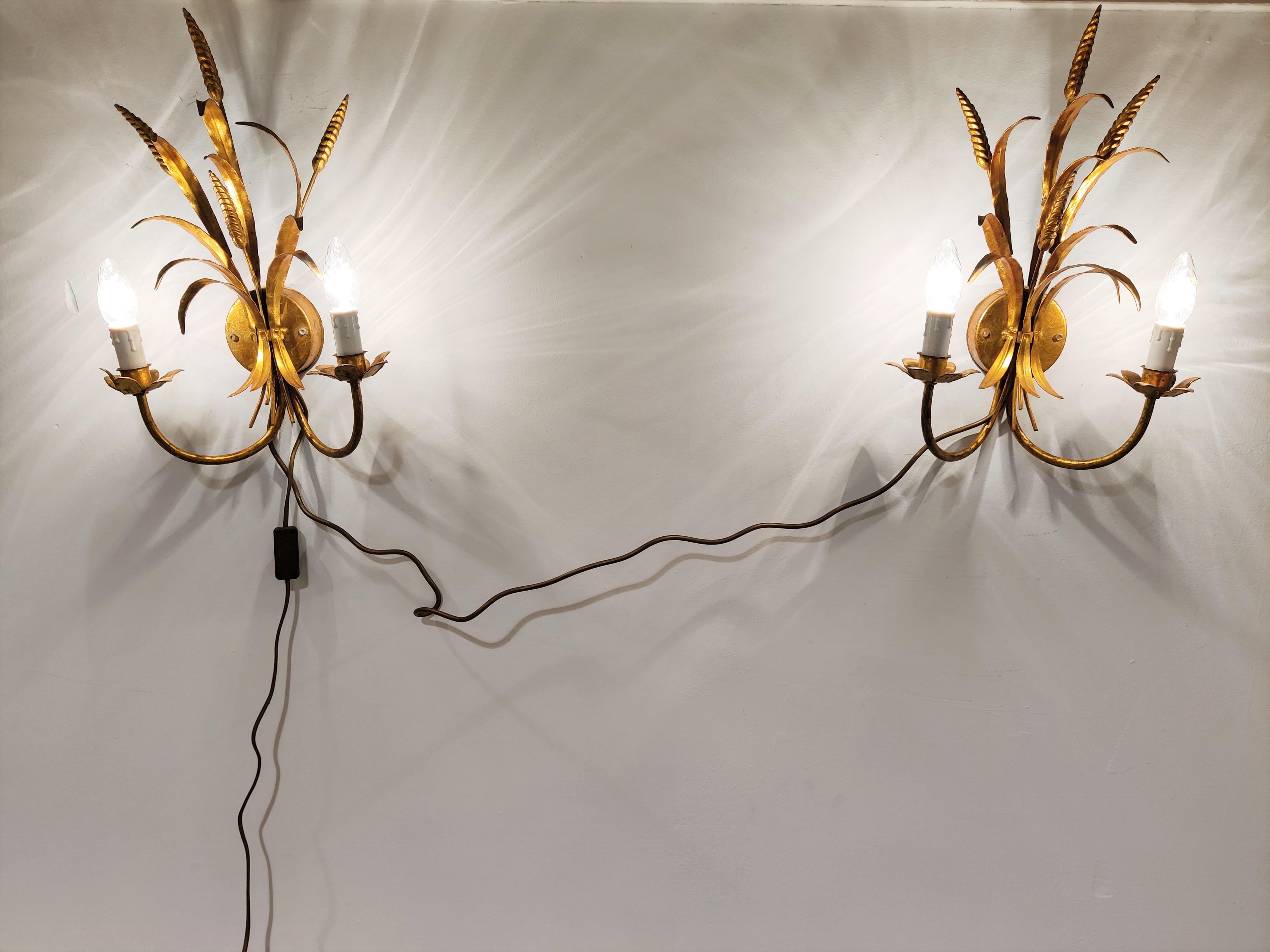 Pair of vintage gilt metal sheaf of wheat wall lamps made in italy in the 1960s.

They are used with E14 candelabra lamps.

Measures: Height: 46cm/18.11
