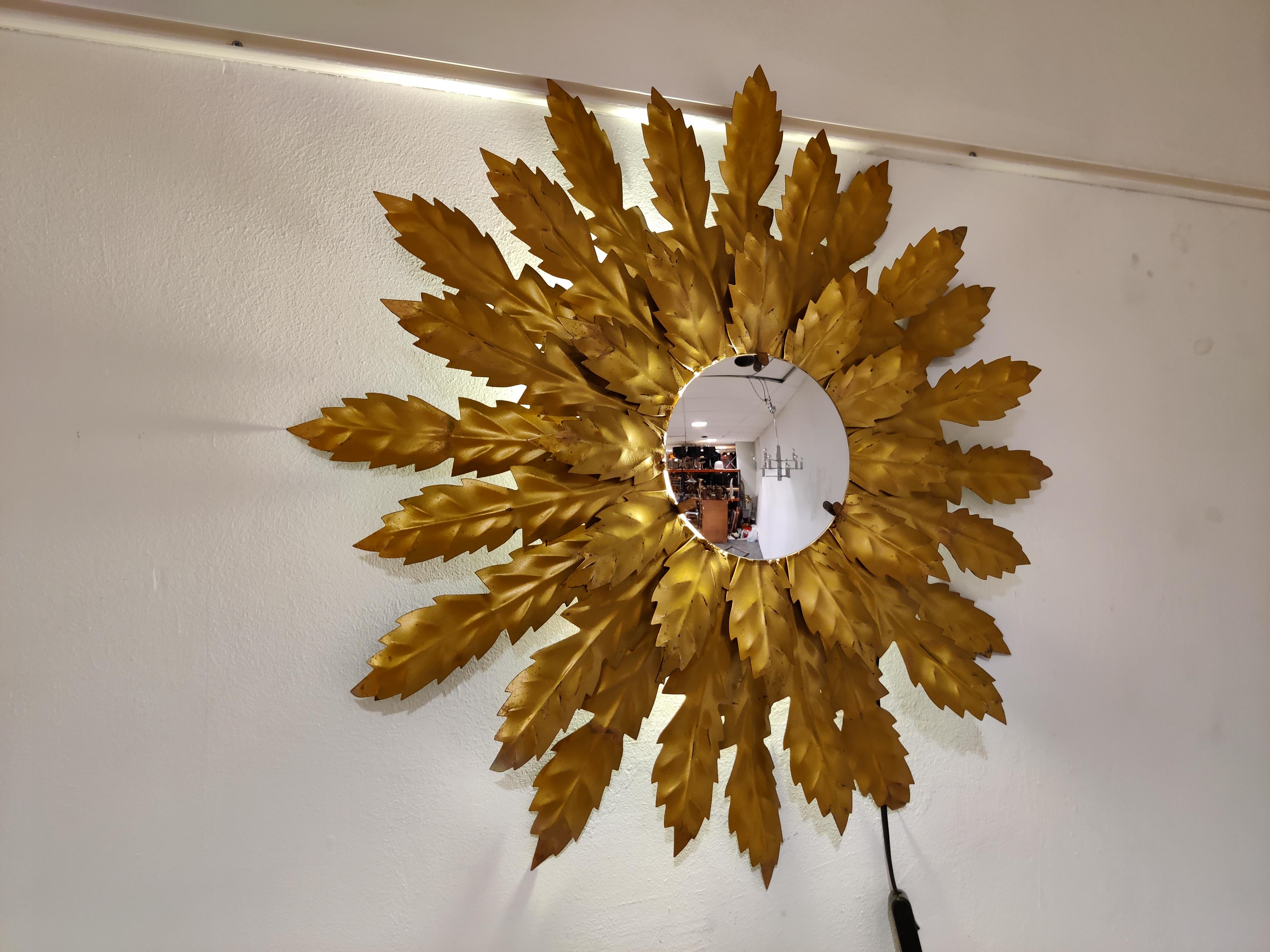 Mid century backlit gilt metal sunburst mirror with convex glass.

This mirror fits in most interiors and is a perfect add-on for a regency style interior.

It has some age related wear.

Thanks to the light at the back of the mirror it emits