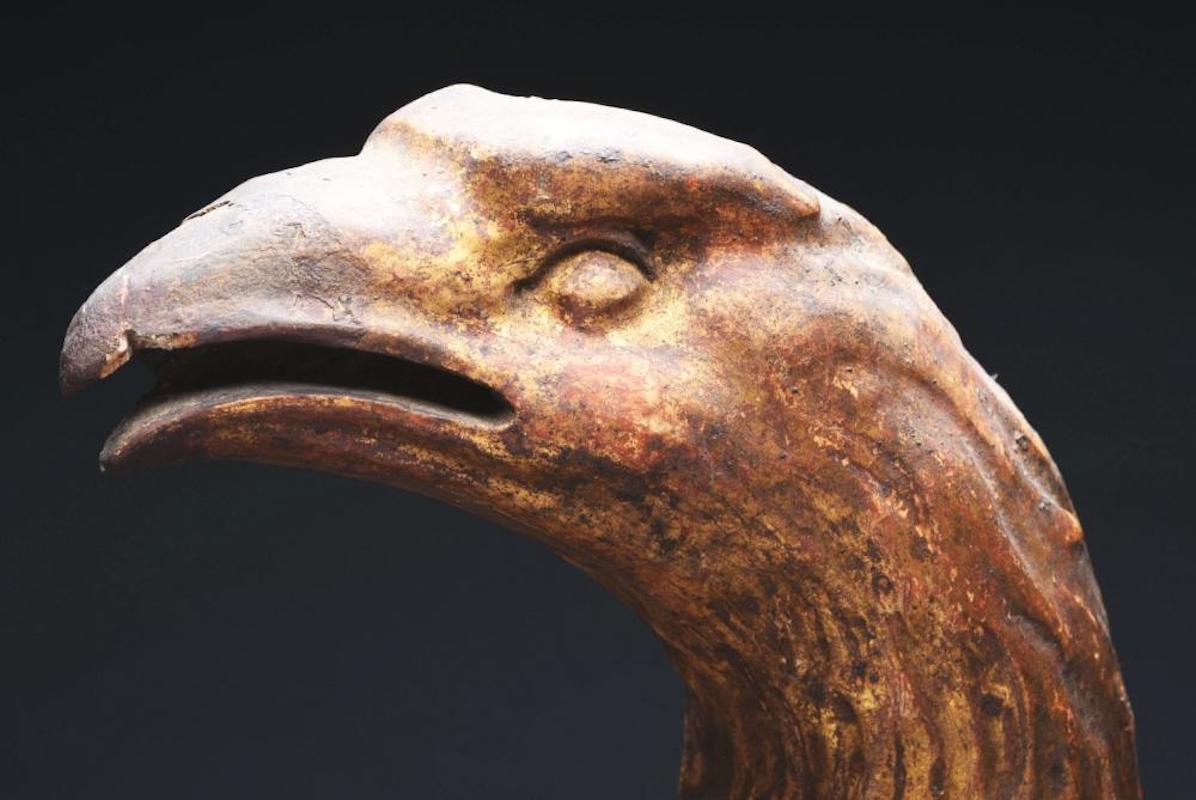 A great example of early American symbolism, this late 18th century gilt eagle wall plaque is shown perched on rocks, branches, and foliage. The eagle’s head and beak are arched and its wings are spread widely, with one pointed at attention. The