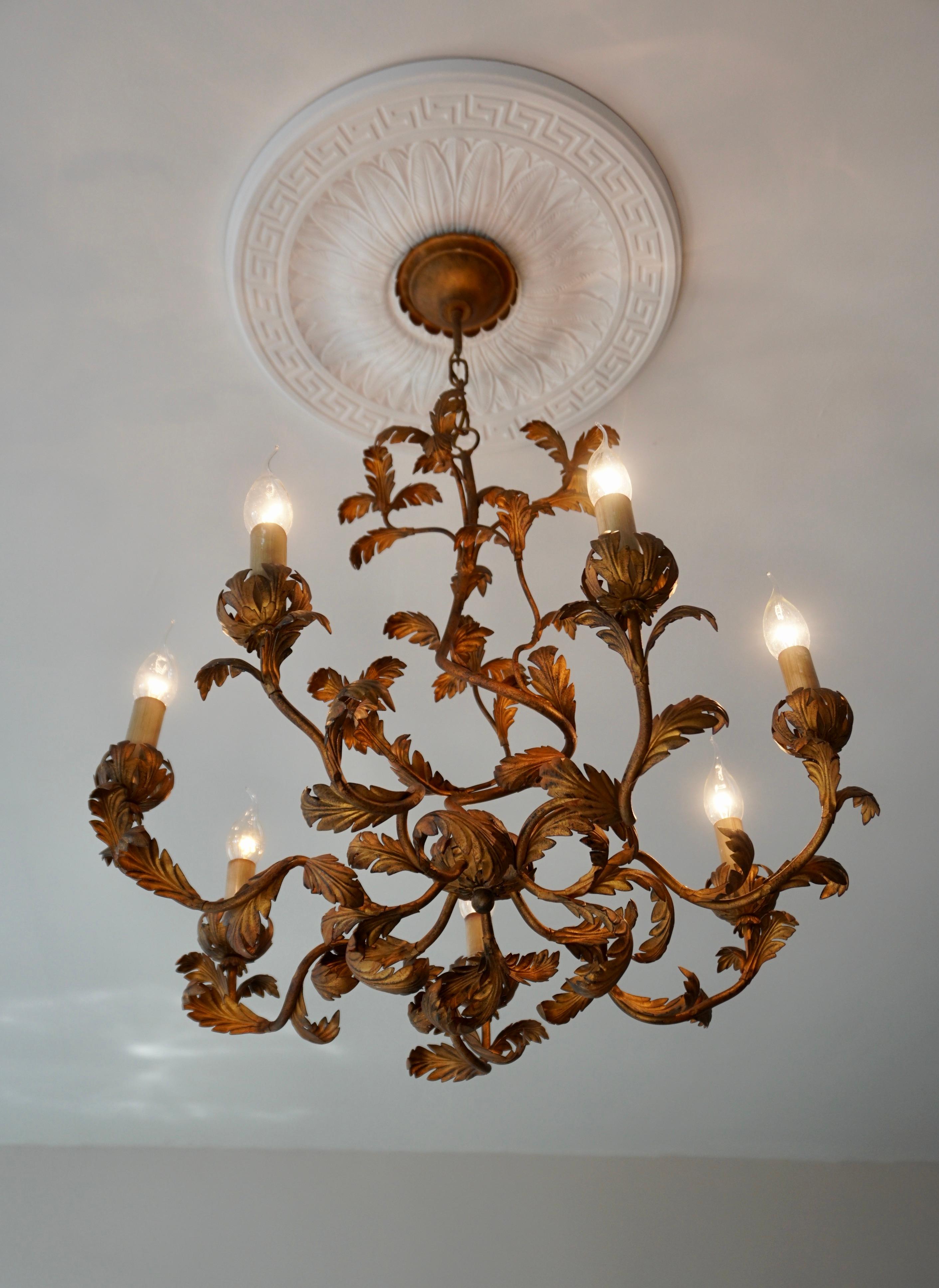 Impressive large mid century gilt tole chandelier, finely made with gilt metal leaves with six lights. Very good vintage condition with minimal signs of age and use.

A Hollywood Regency style six-light gilt metal chandelier with tôle palm fronds.