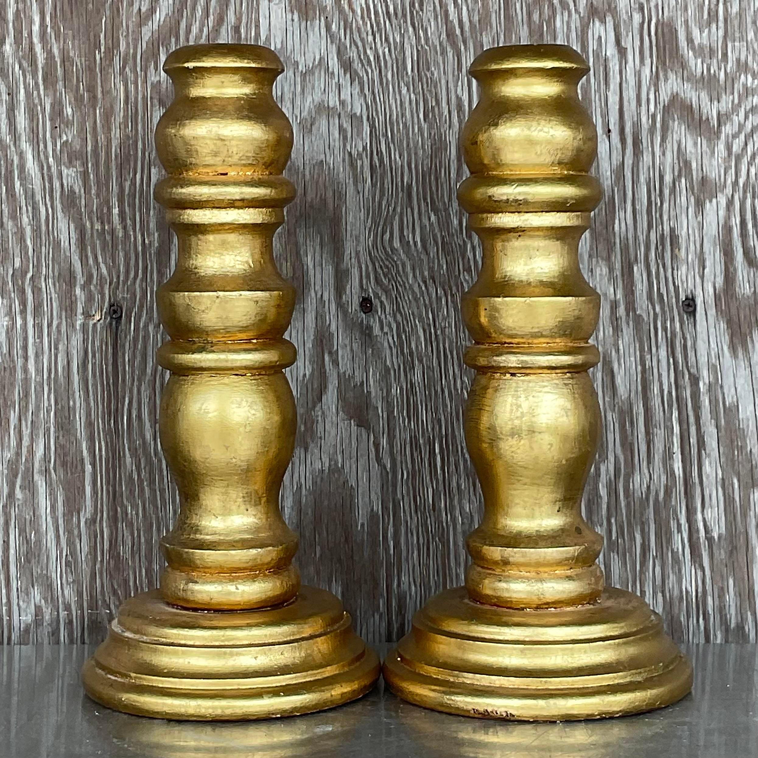 A gorgeous pair of wooden candlesticks. Chic wood turned design with a bright gilt finish. Acquired from a Palm Beach estate.