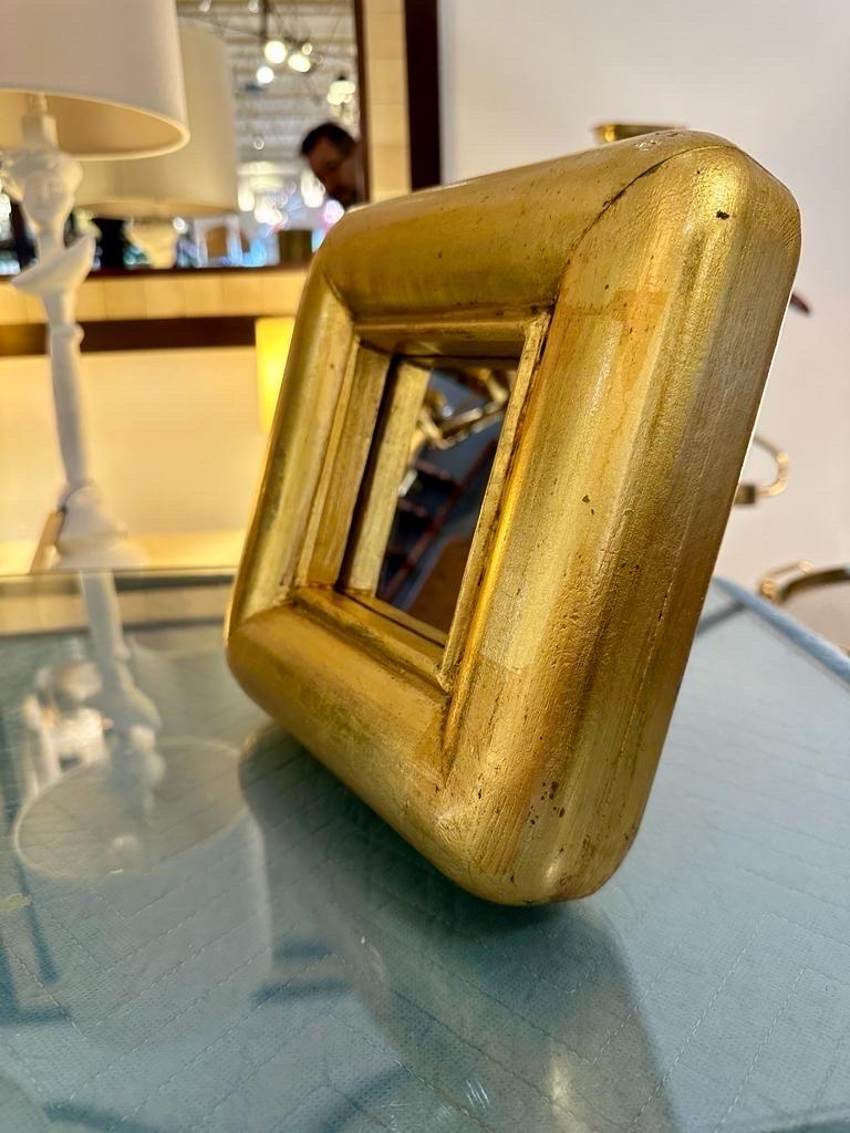 This thick carved petite gilt wood frame vanity mirror is a wonderful desk accessory or just a shelf piece.  THIS ITEM IS LOCATED AND WILL SHIP FROM OUR EAST HAMPTON, NY SHOWROOM.