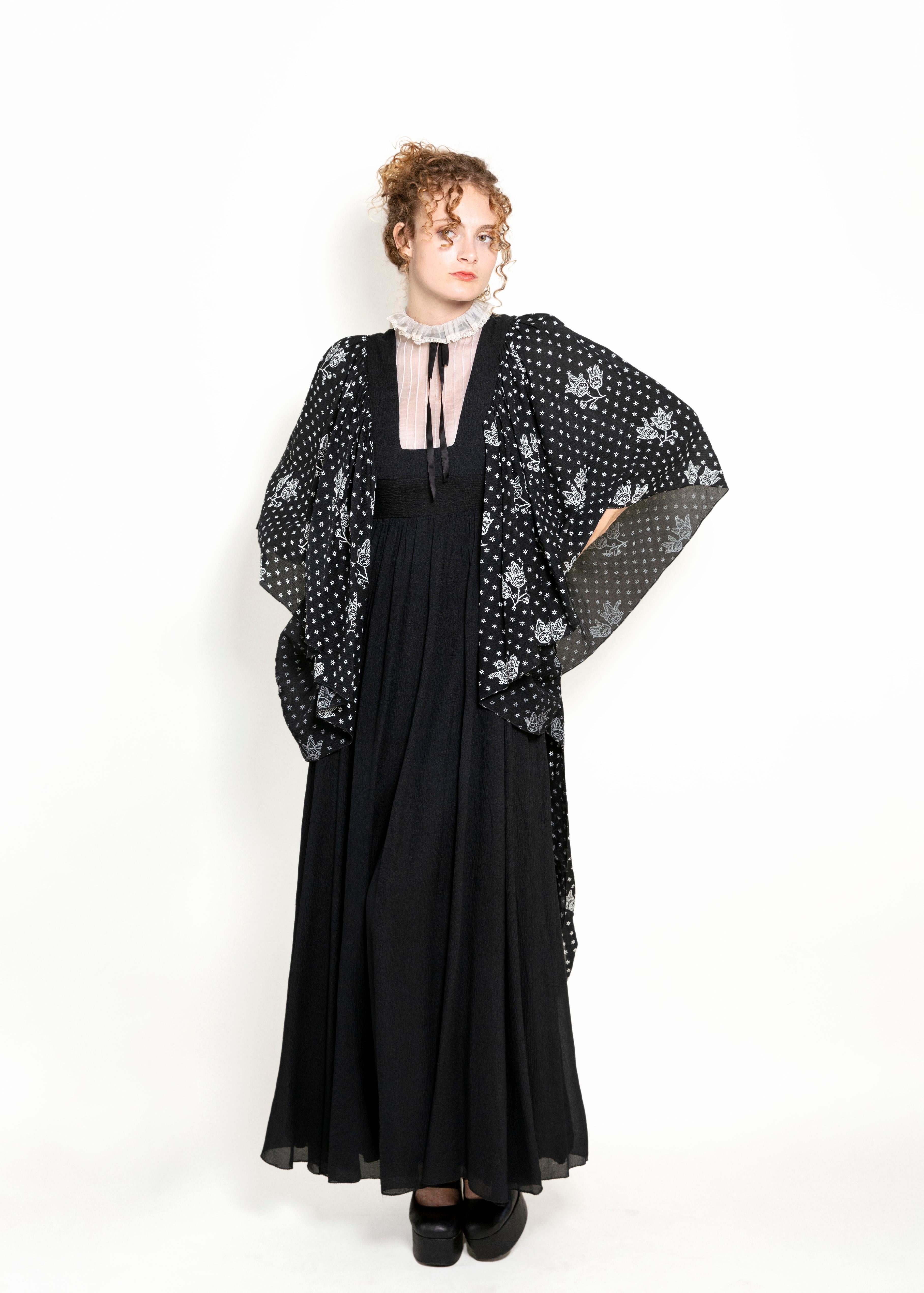 Faites une déclaration intemporelle dans cette robe vintage exclusive de Gina Fratini datant des années 1970. Confectionnée en soie luxueuse et dotée de manches d'ange et d'un col à volants, cette pièce ne manquera pas de rehausser votre garde-robe.