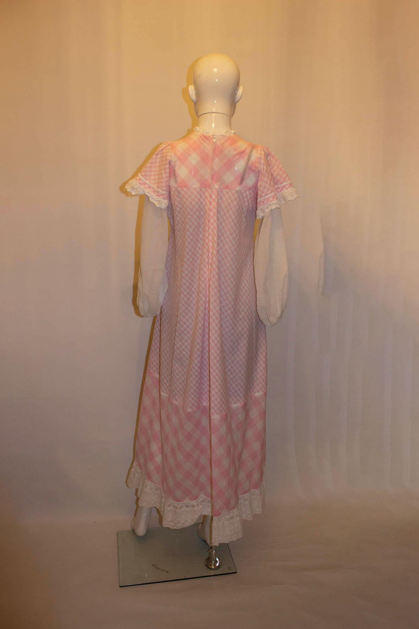 Ein umwerfendes Vintage-Kleid von Gina Fratini für Paula Lee. Das rosa-weiß karierte Modell mit zentralem Reißverschluss am Rücken und Rüschen an den Armen ist ein echter Hingucker. 
Maße: Büste 36'', Länge 54''