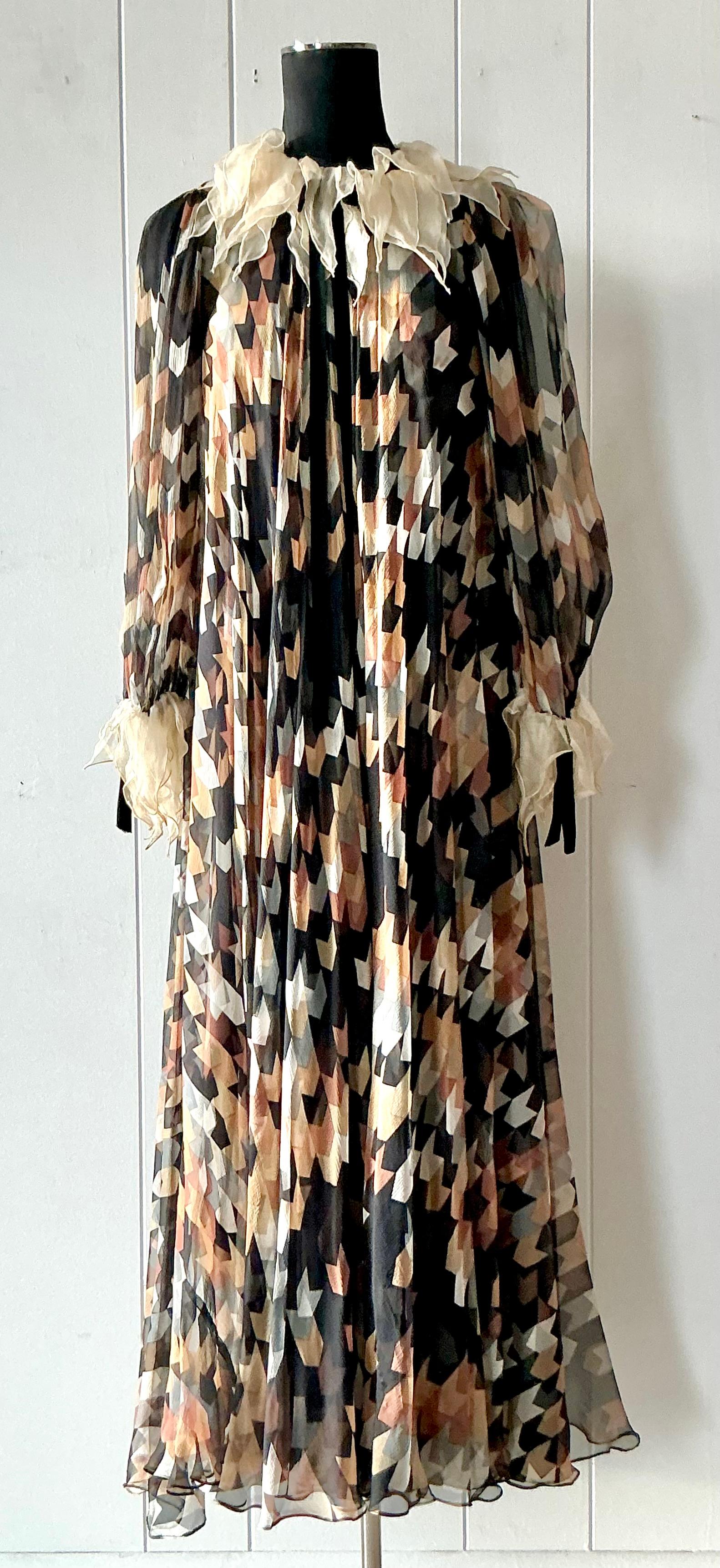 Eleganza eterea con questo squisito maxi abito vintage in seta di Gina Fratini, vera incarnazione della moda romantica degli anni Settanta. Rinomata per i suoi modelli ispirati alle fiabe, Fratini realizzava capi che fondevano un fascino stravagante