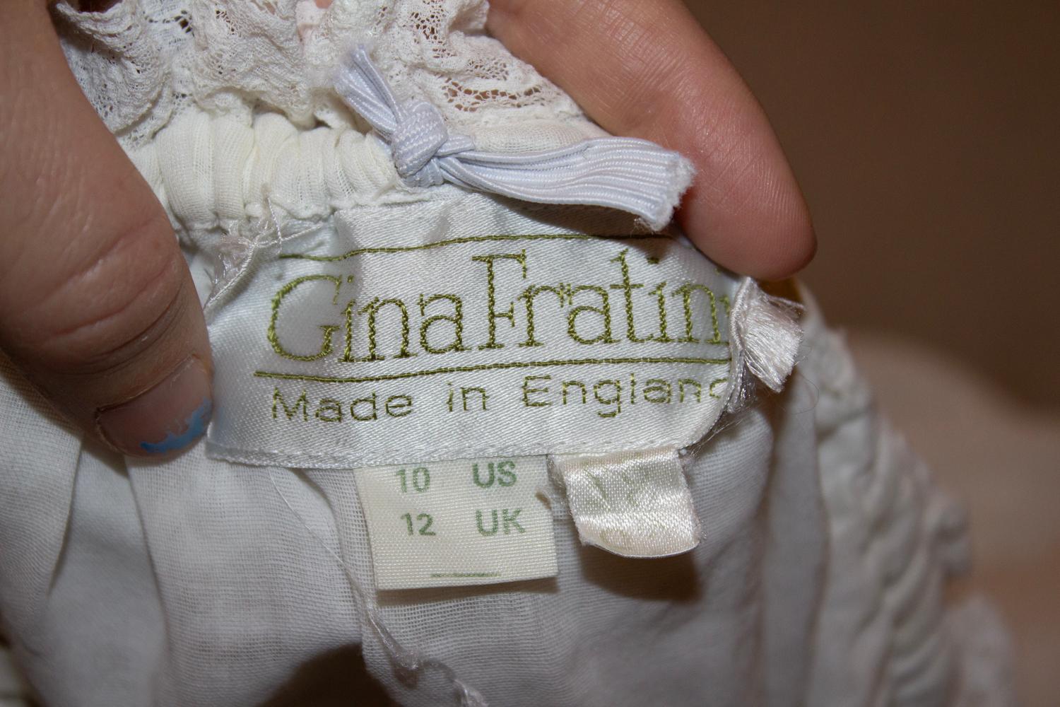 A pretty vintage top by British designer Gina Fratini. 
In white cotton and lace, the top can be worn on or off the shoulder. It has cap sleaves with lace detail and pleats and lace on the front. 
Measurements: Bust 36'', length 21''