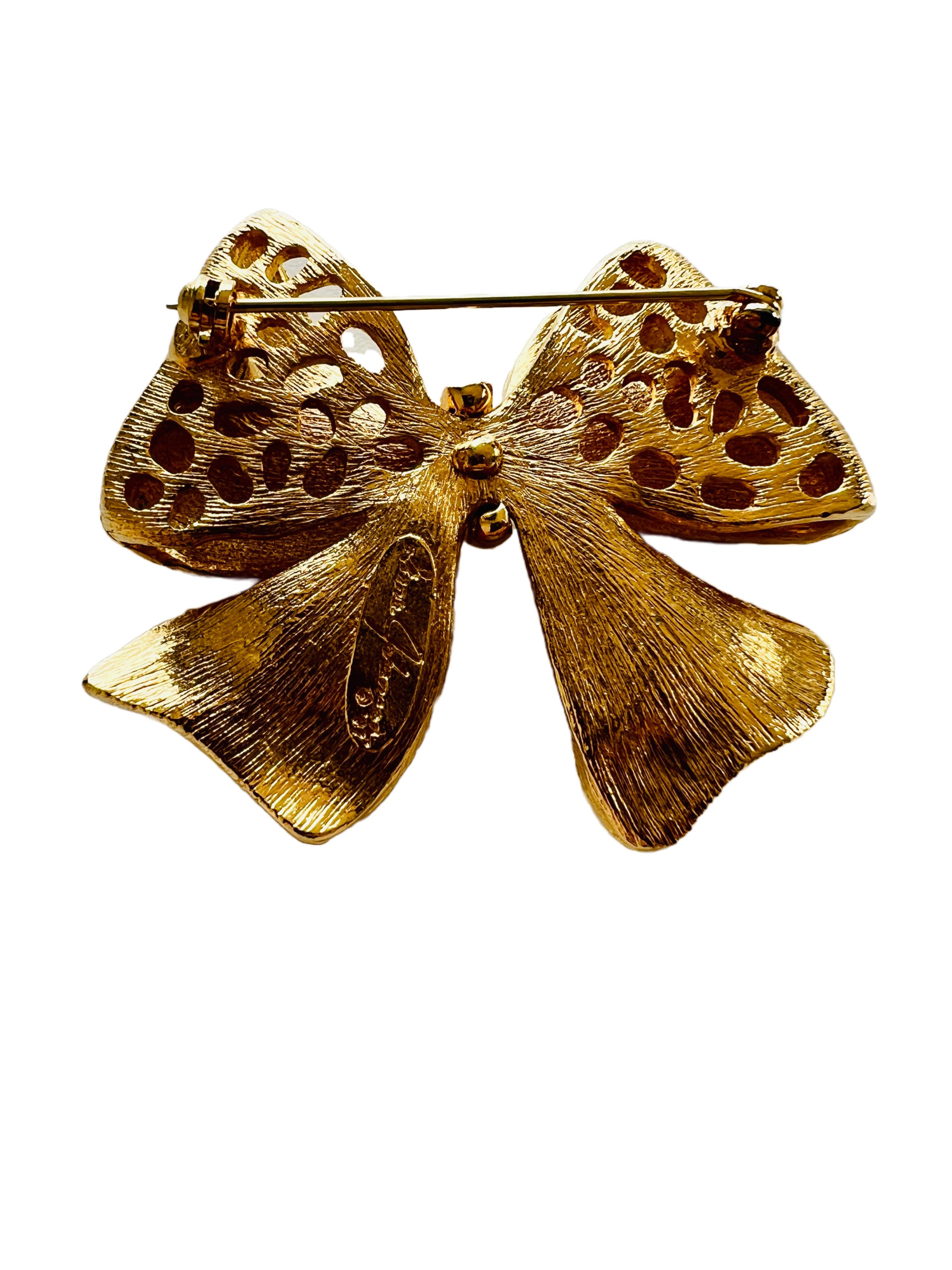 Add a touch of glamour to your outfit with this stunning vintage gold plated bow brooch by Ginnie Johansen. 

Size: 2-1/8 wide