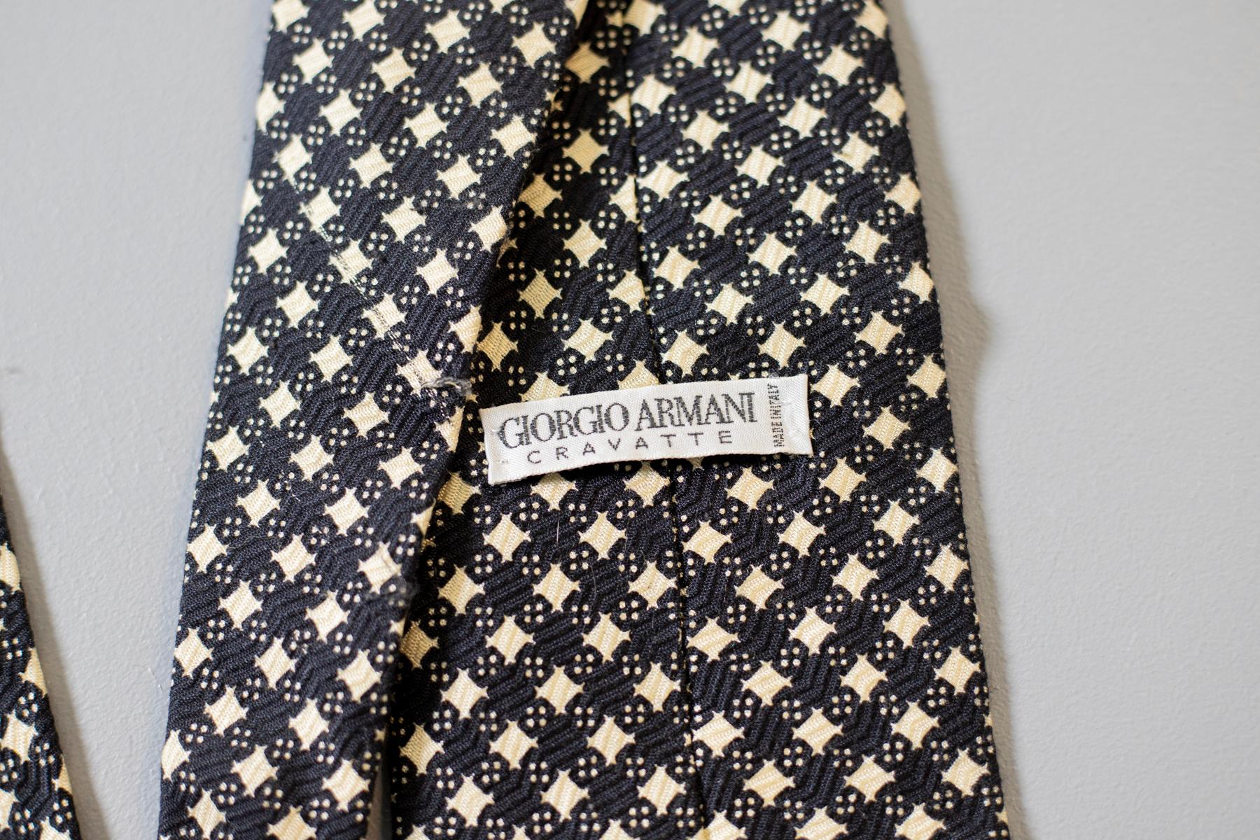 Classique, mais unique, cette cravate vintage tout en soie de Giorgio Armani est le bon choix pour une soirée formelle. A carreaux noirs et blancs et portant l'étiquette Giorgio Armani, cet accessoire vintage se marie parfaitement avec une chemise