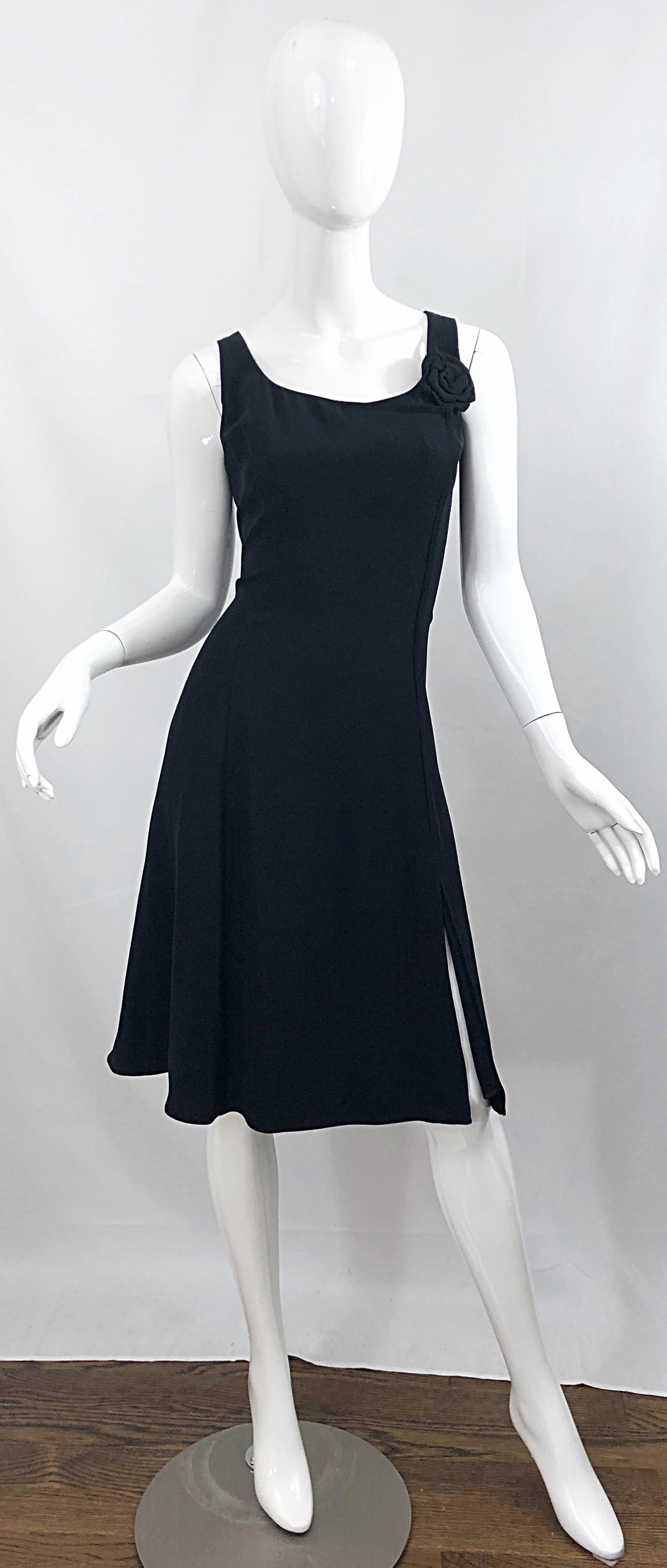 The ultimate chic vintage GIORGIO ARMANI Size 12 / 44 flirty little black dress! Features a tailored bodice with a forgiving skirt. Slit up the left hem reveals just the right amount of leg. Rosette at left shoulder adds just the right amount of