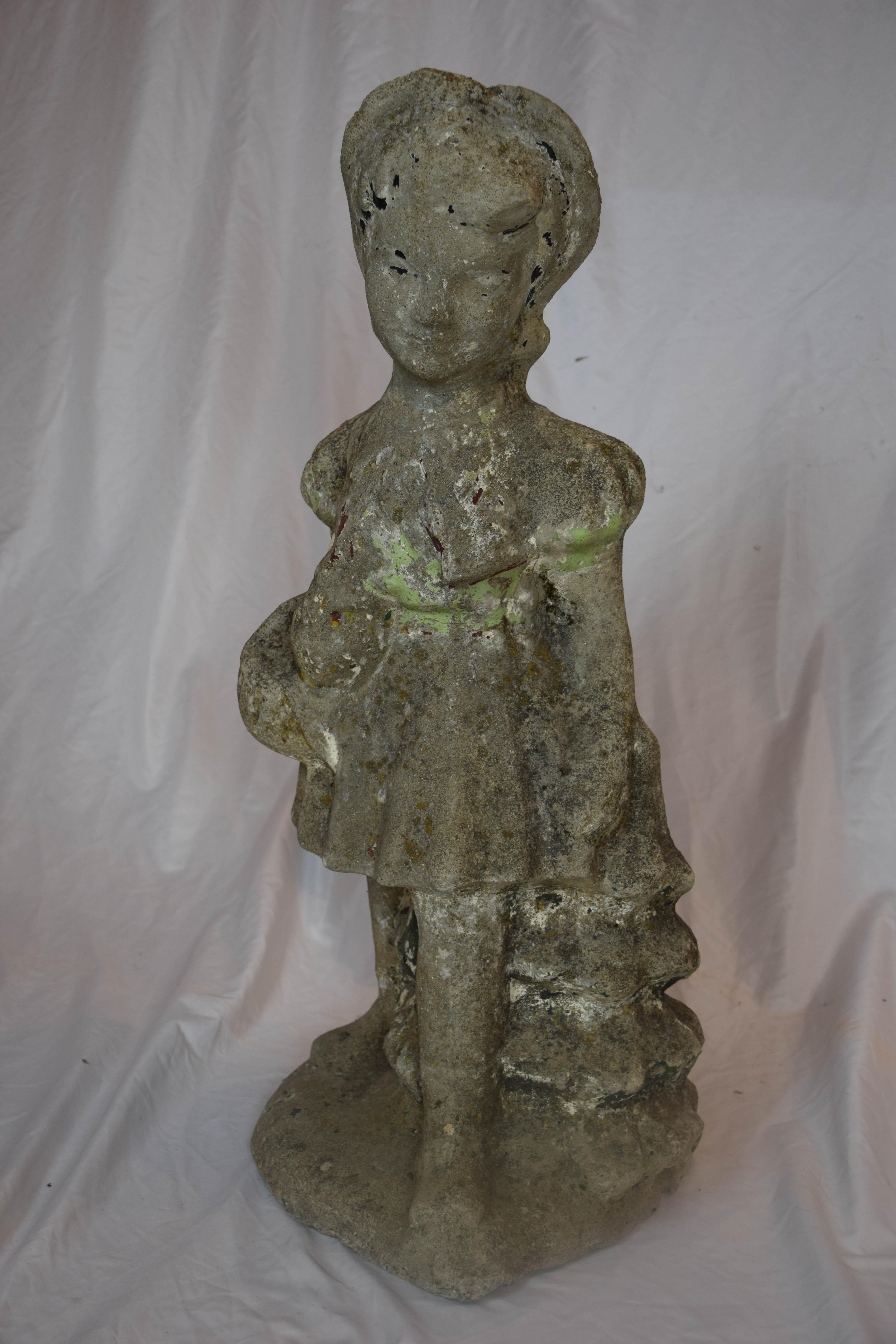 This vintage girl garden statue has a shabby weathered patina. Still showing signs of old chippy paint. The girl is carrying a basket in her left hand. The years have softened her edges. Perfect for any English, French country, Farmhouse or lake