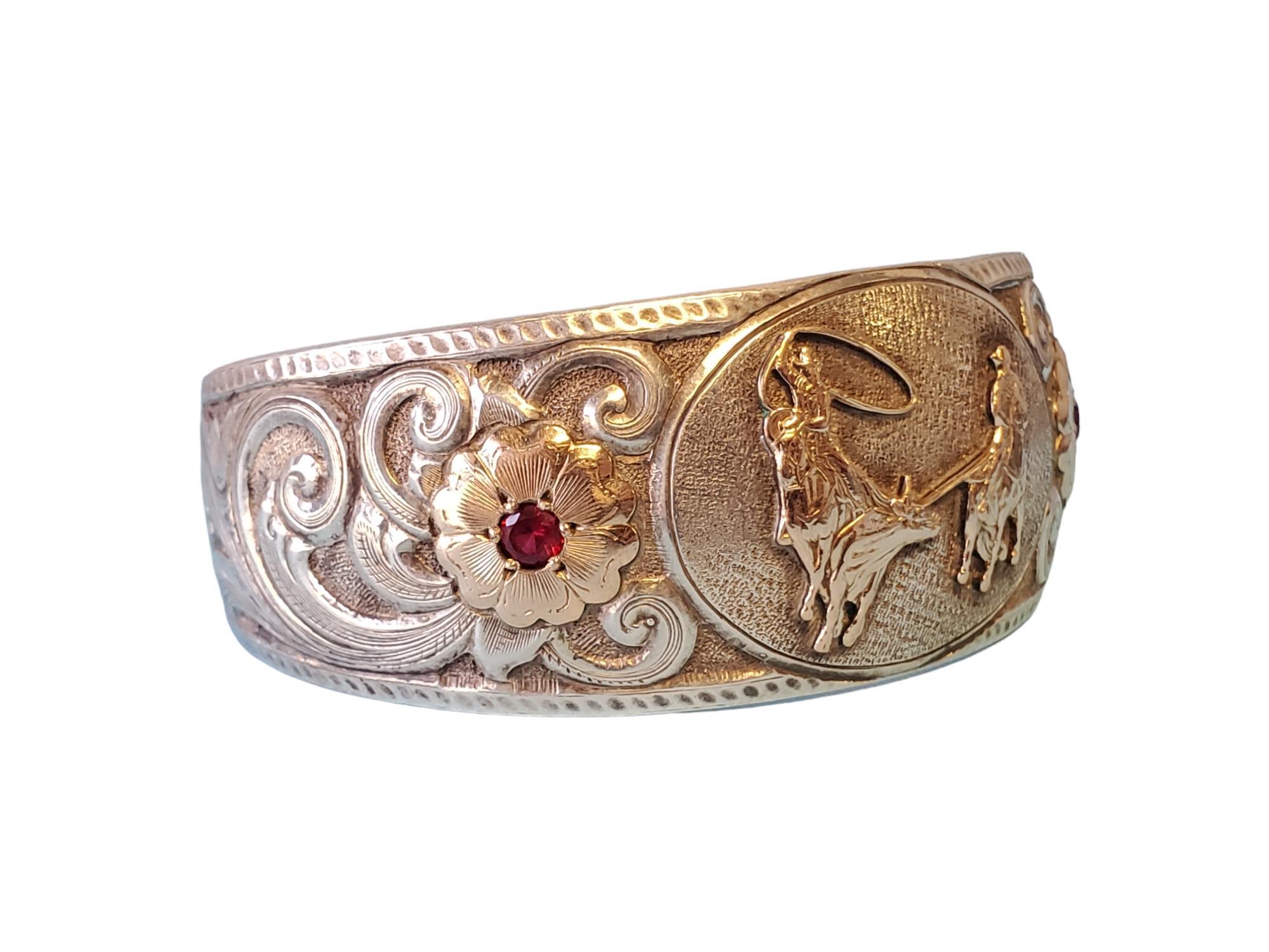 Vintage Gist Signed Sterling Cuff Bracelet with Cowboy Motif

Listed is a signed designer Gist sterling cuff bracelet. This wonderful sterling cuff features red stones with gold accented floral patterns and cowboys roping in the center. The cuff