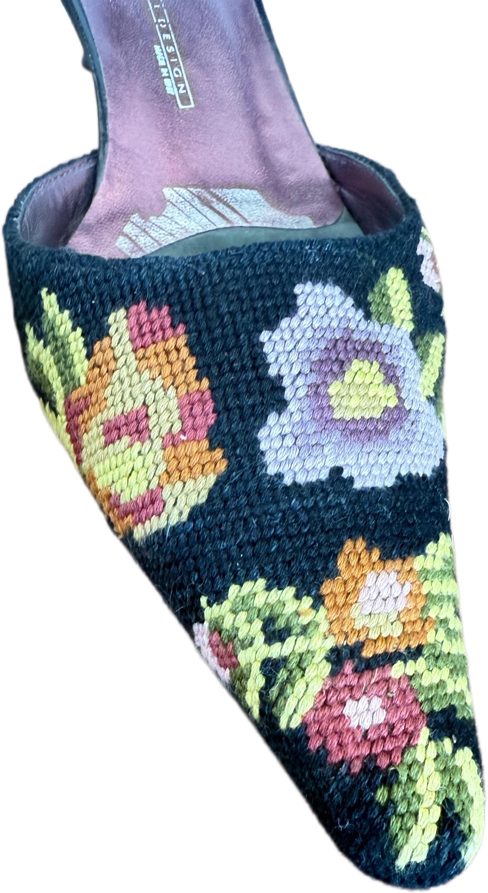 These vintage Giuseppe Zanotti Couture mules, crafted in Italy in the 1990s, combine artisanal detail with timeless wearability. The uppers feature hand-stitched floral needlepoint embroidery in bold, romantic colors set against a dark ground,