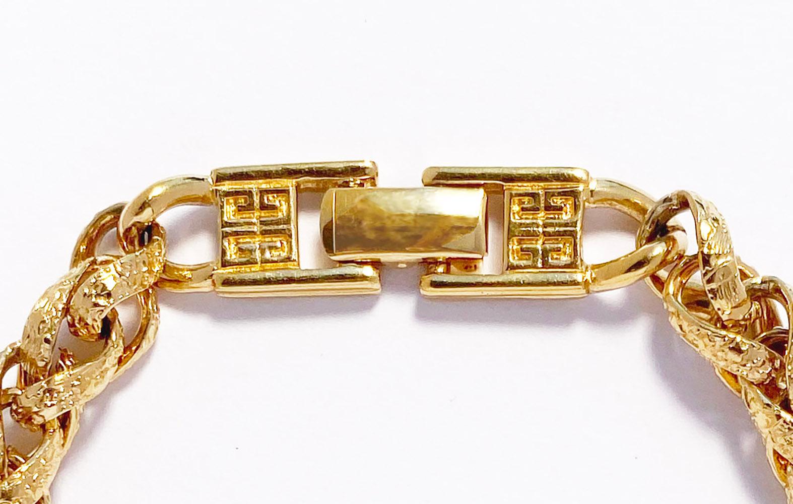 1980s Vintage Givenchy Byzantine link chain bracelet in gold plate.  This vintage bracelet features ornate textured links with a signature Givenchy logo clasp.   Bracelet measures 7 1/4 inches in length, width approximately 3/8 inch with a foldover