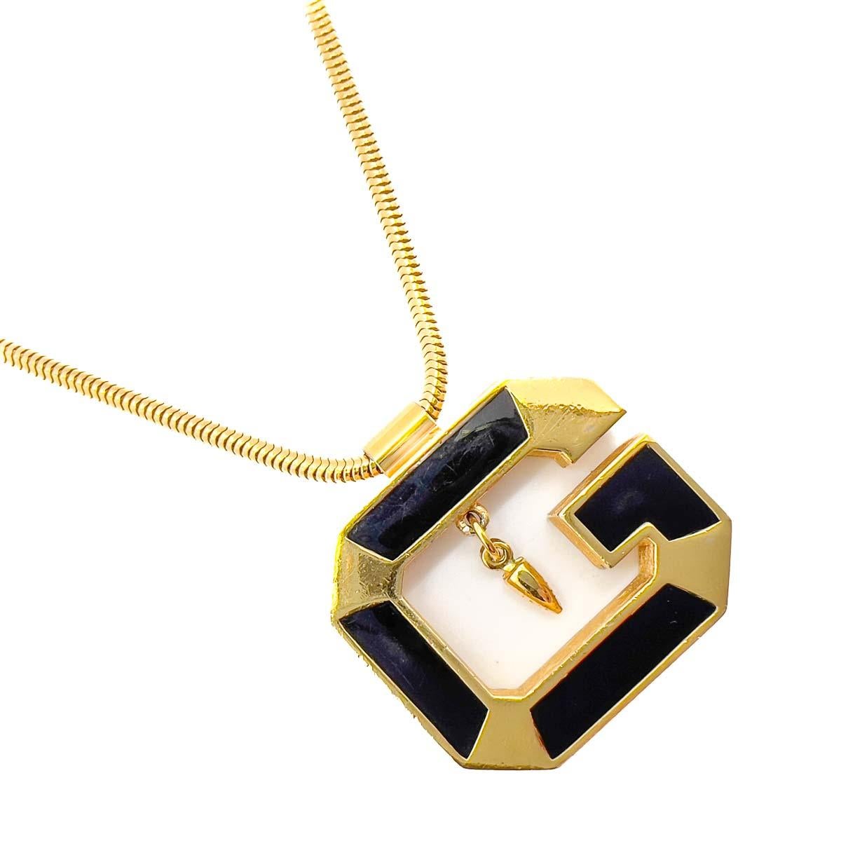 A super cool Vintage Givenchy G Necklace. A slinky snake chain adorned with a large Givenchy G. Enamelled in black and finished with a central drop this Givenchy jewel is a couture logo lover's dream.
One of the late great 20th century couturiers,