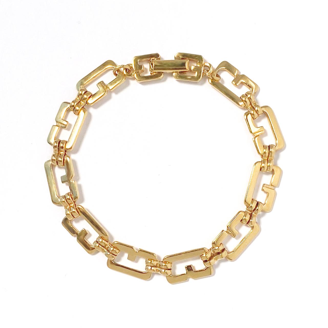 1980s Vintage Givenchy G-link chain bracelet in gold plate.  This vintage bracelet features G-shaped logo links with a double G logo clasp.   Bracelet measures 7 1/4 inches in length, width approximately 5/16 inch with a foldover clasp closure at