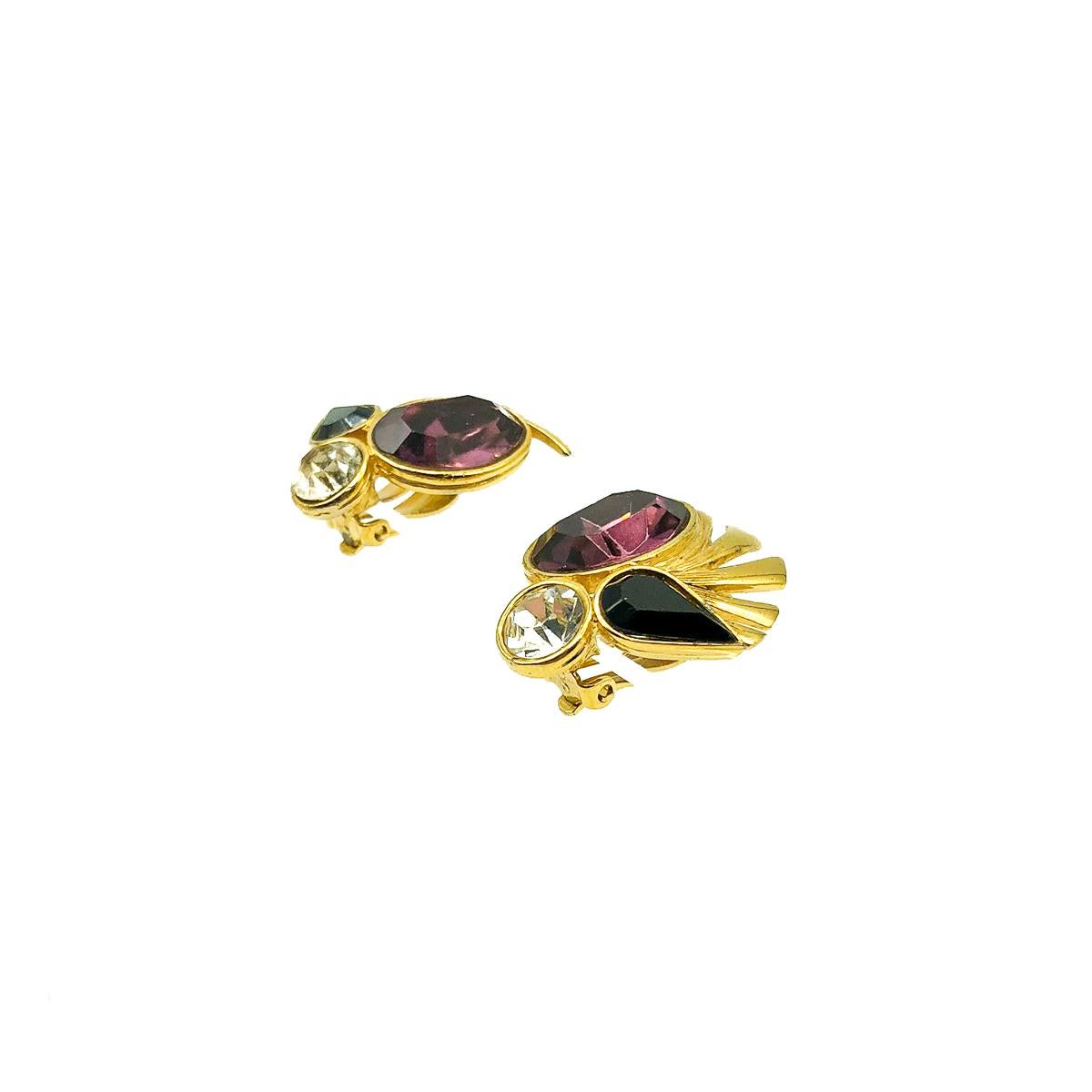 Beautiful Vintage Givenchy Amethyst Earrings. Featuring a large faceted amethyst oval crystal with contrasting black and clear fancy cut crystals with feather style detailing for an extra style shot. In gold plated metal. 3.2cms. In very good