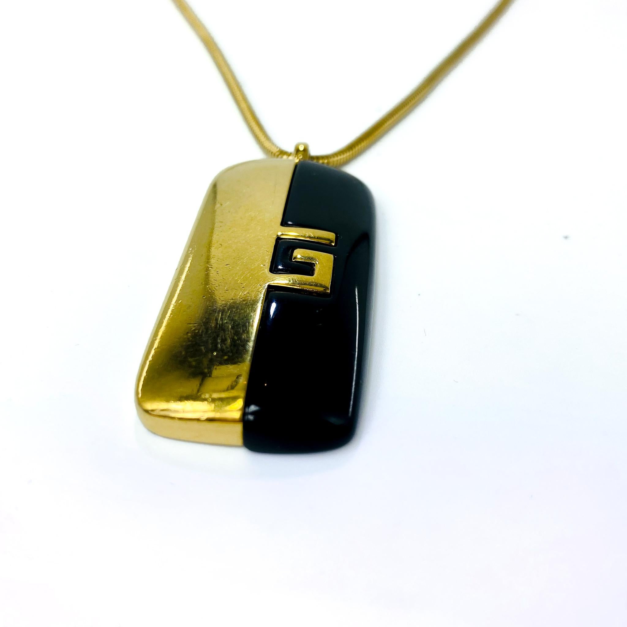 Vintage Givenchy Gold Plated Pendant Necklace 1970s

Super cool pendant necklace from the iconic Hubert de Givenchy. Made in France in the 1970s, this incredible necklace has a gold plated fine snake chain with a rectangular black resin and gold