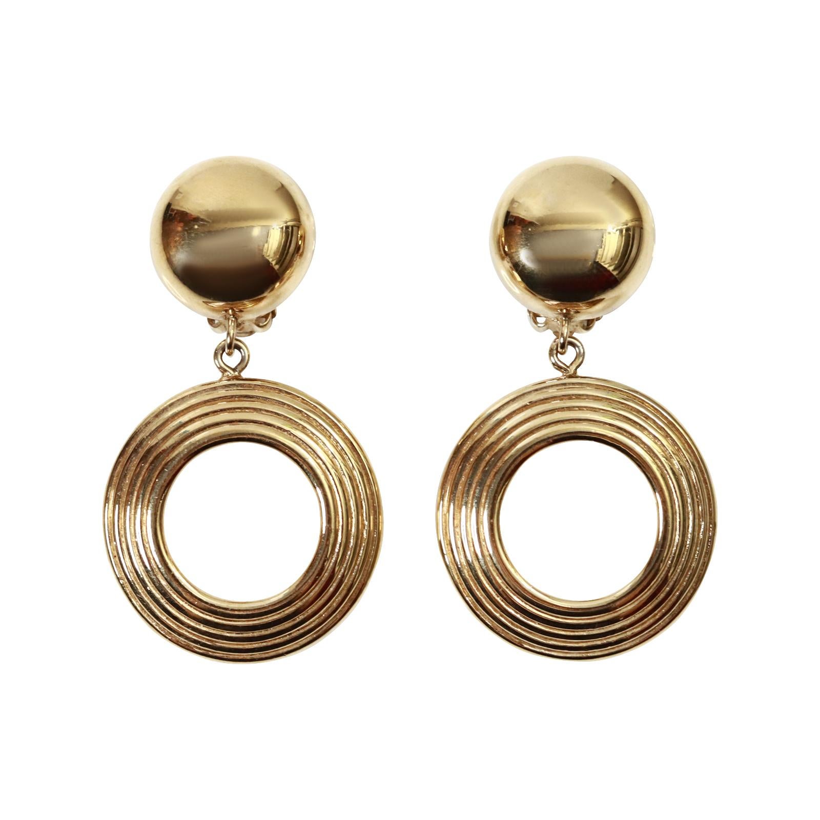 Vintage Givenchy Gold Tone Heavy Textured Front Facing Dangling Hoop Earrings.  Everyone needs a Classic Hoop like this in their wardrobe.  Spices up all your outfits. W. Clip on.

Now these are a great pair of dangling hoops!

