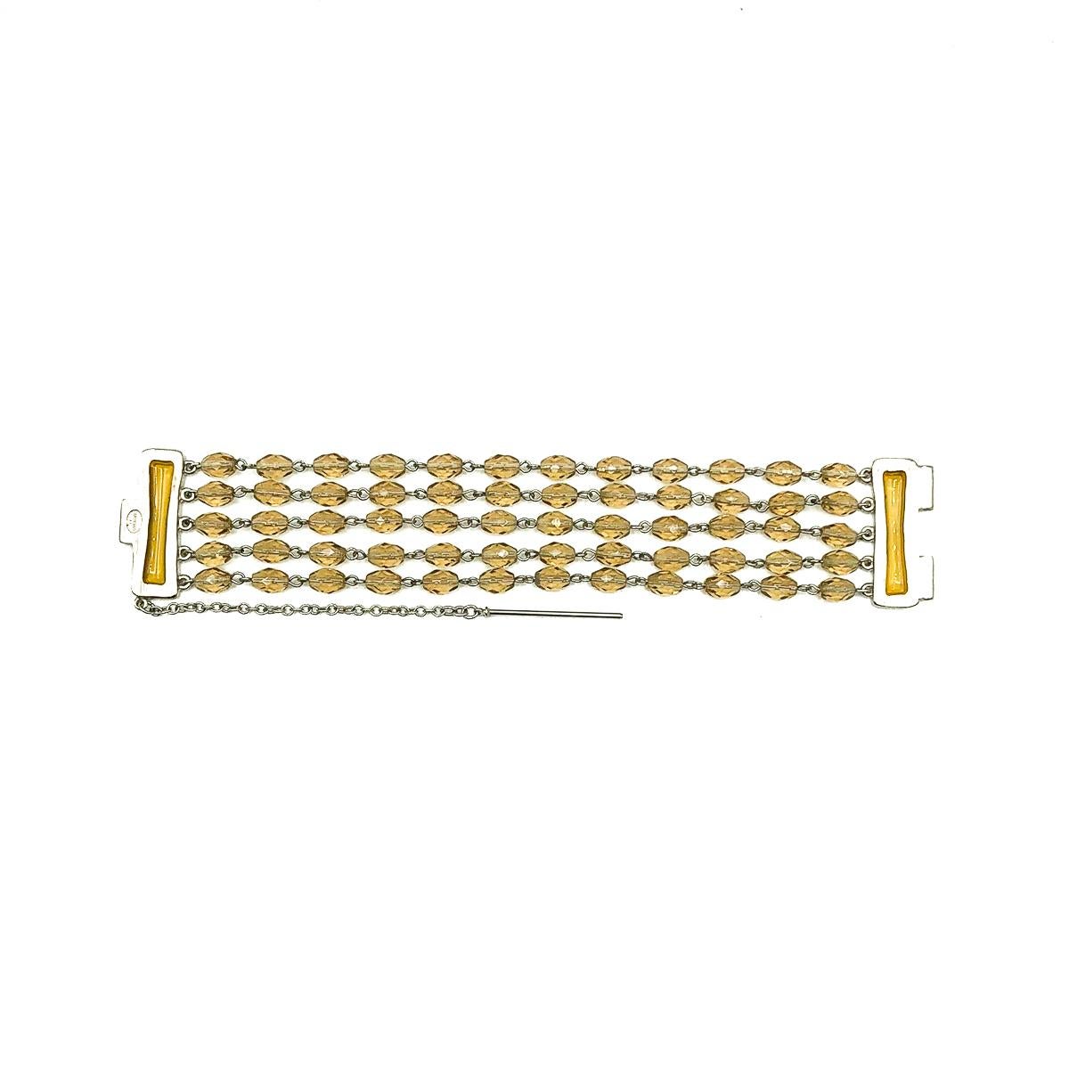 A Vintage Givenchy Citrine Glass Bracelet. Crafted with brushed silvertone metal, faceted glass citrine beads and resin plaques in the feature clasp. In very good vintage condition, signed and approx. 20cm long by 3.6cm wide  A gorgeous piece from