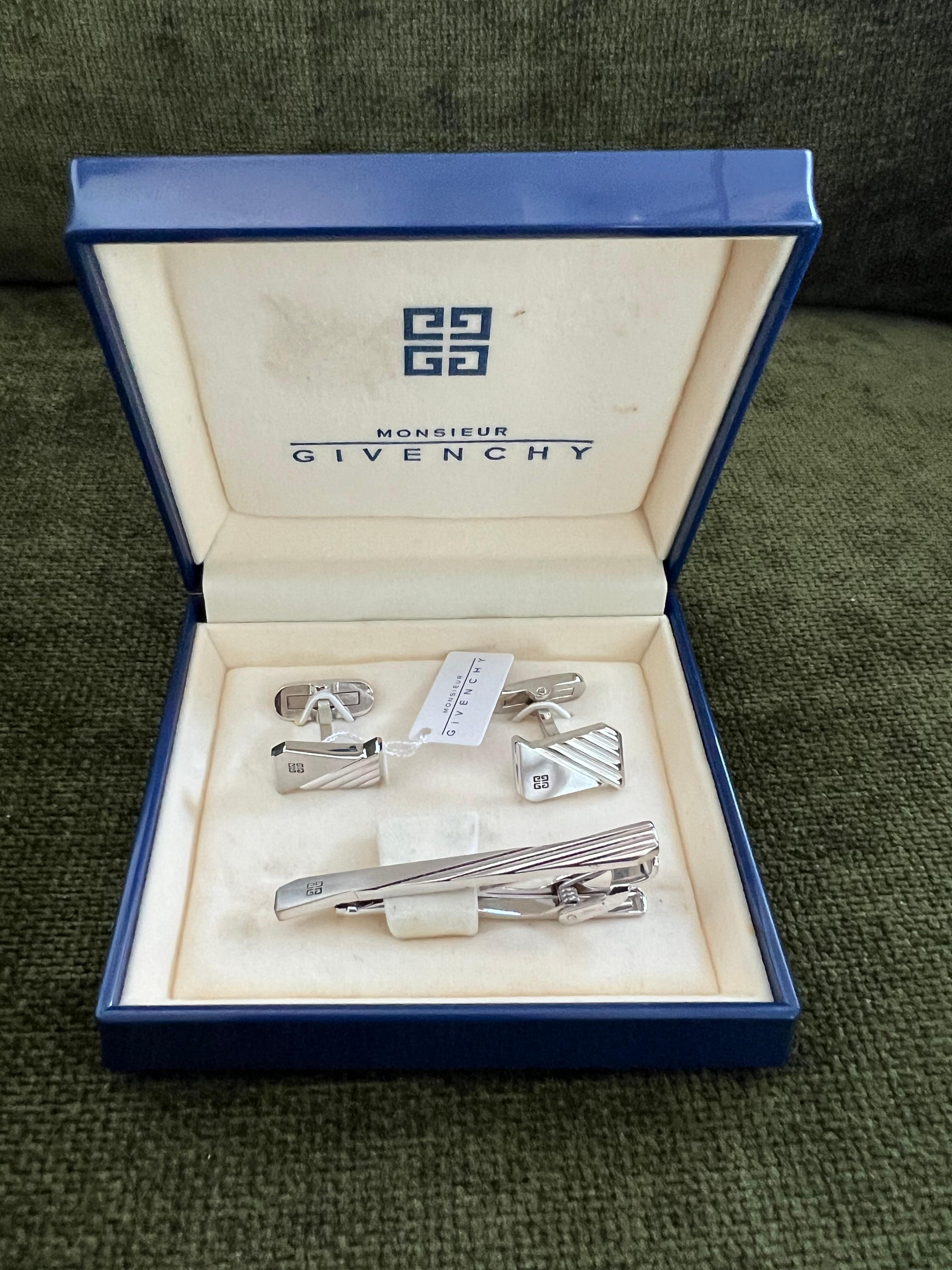 Vintage Givenchy Steel Logo Cufflinks and Tie Clip Brand Mark Emblem “Circa 1990” 

Stainless Steel Givenchy Logo Cufflinks and Tie Clip, Brand Mark Emblem Cuff Link, Vintage Cufflinks & Tie clip 3 Piece Set in Original Case 
This stunning set