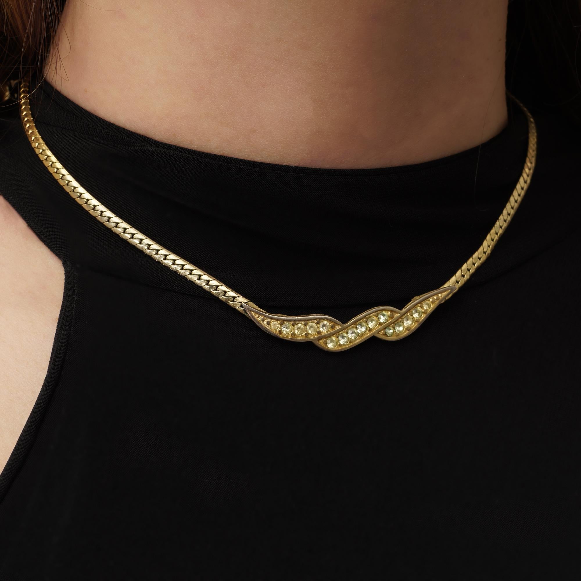 Transport yourself to the epitome of vintage glamour with this Vintage Givenchy yellow-tone necklace, crafted circa the 1990s, radiating the timeless allure and sophistication synonymous with the Givenchy brand.

Exquisitely designed and expertly