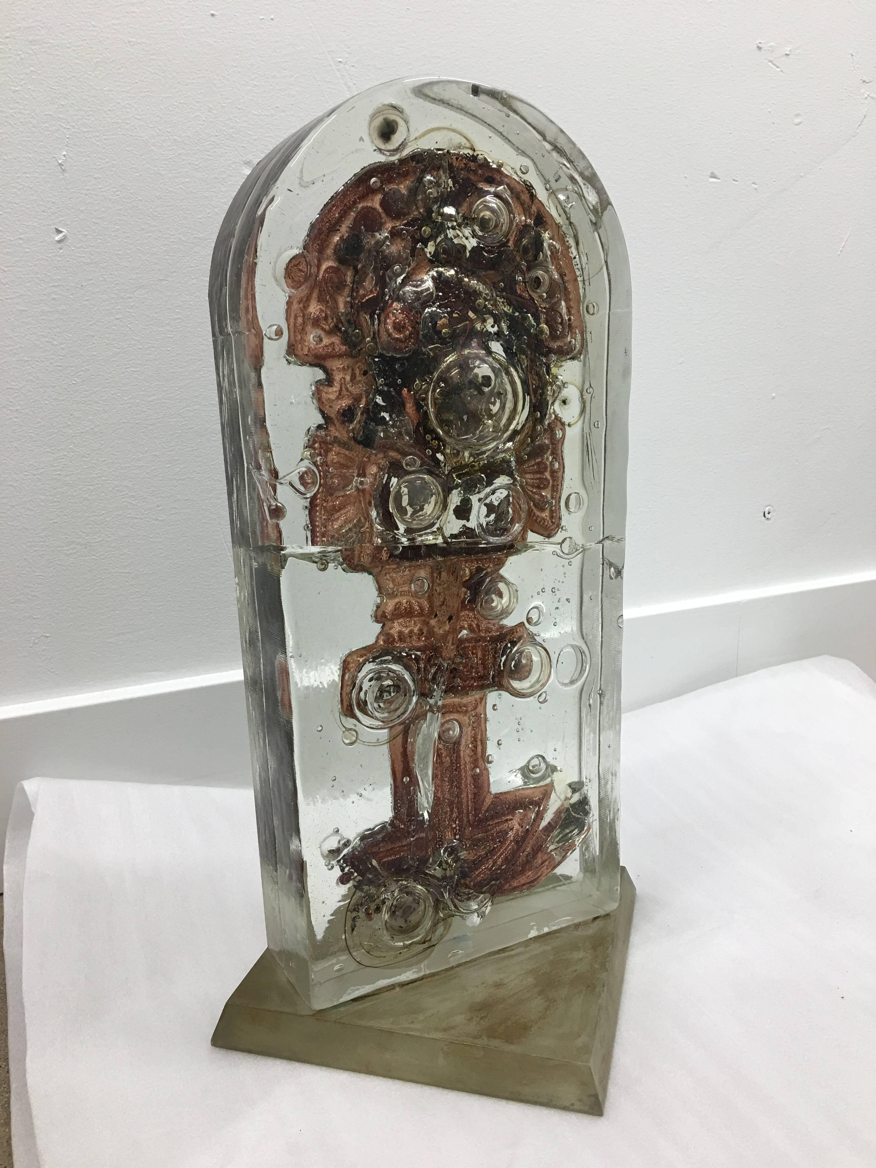 This is a unique and one-of-a kind sculpture combining a copper infused interior within a glass capsule. This piece is mounted on a wooden base. Found in Arizona, where copper mines are abundant this piece may have a pedigree that remains a mystery-
