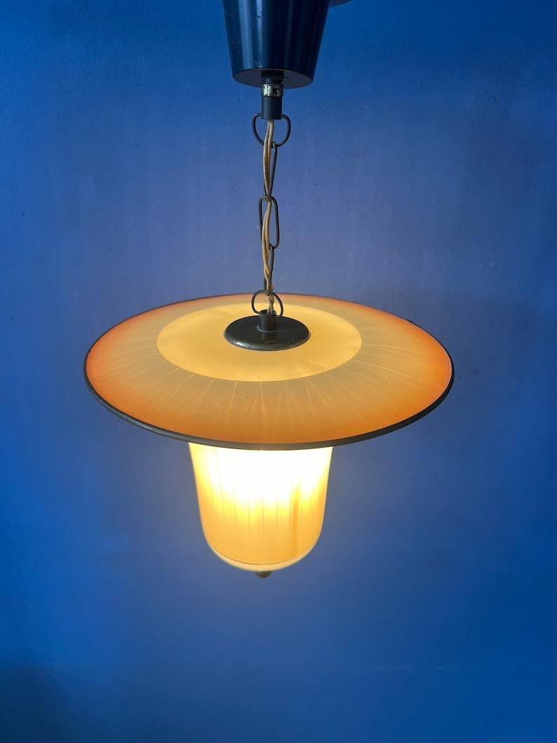 Lampada a sospensione in vetro stile lanterna anni '50 con struttura in ottone. La lampada ha un bellissimo vetro colorato a righe. La lampada richiede una lampadina E27/26.

Informazioni aggiuntive:
Materiali: Vetro, metallo
Periodo: