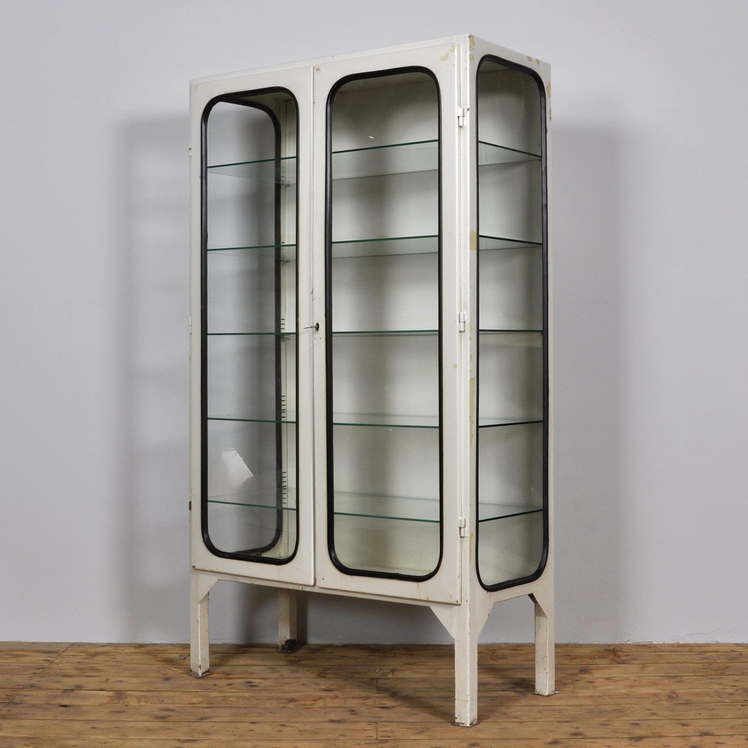 This medicine cabinet was designed in the 1970s and was produced circa 1975 in Hungary. It is made from iron and glass, and the glass is held by a black rubber strip. The cabinet features five adjustable glass shelves and functioning lock. Came out