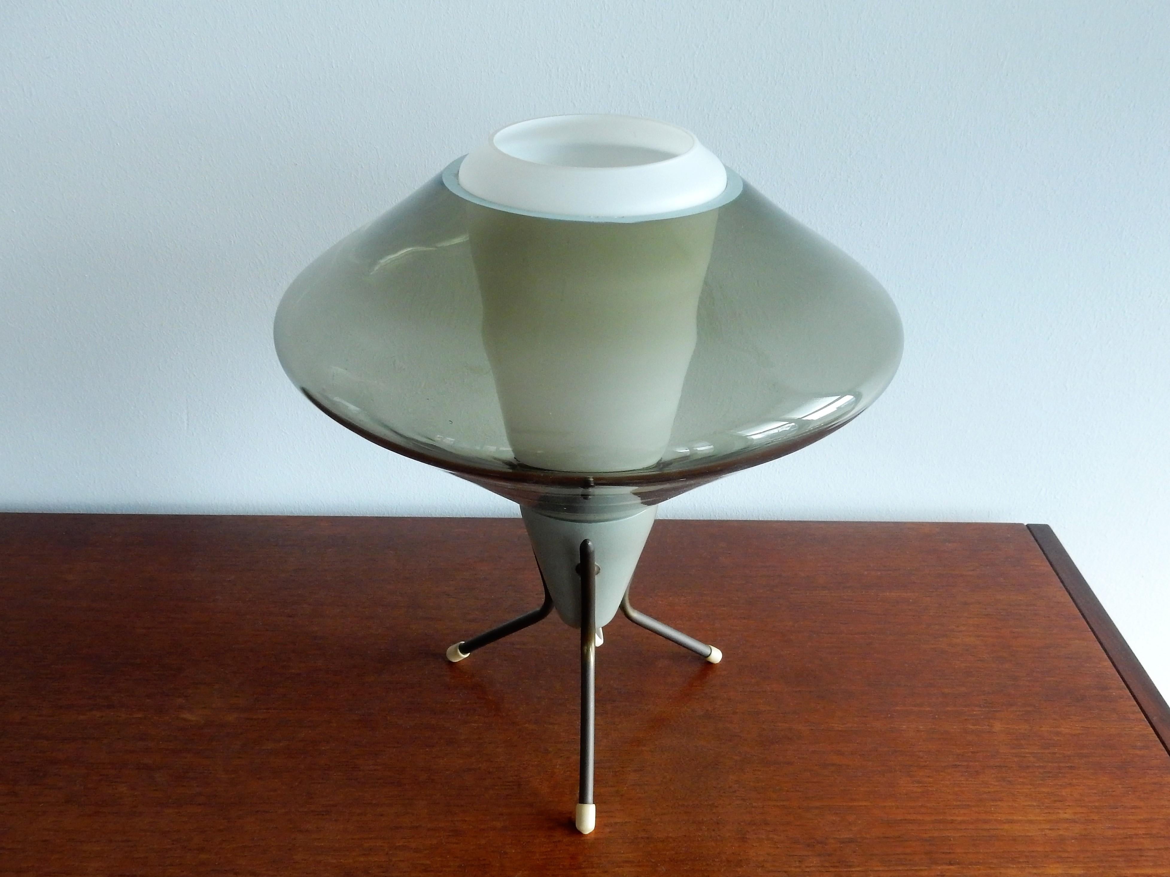 This is a nice tripod table lamp made of metal, opaline and green smoked glass. It has a futuristic Space Age shape and gives a very atmospheric and warm light. It is in a very good condition with some signs of age and use, as pictured. This design
