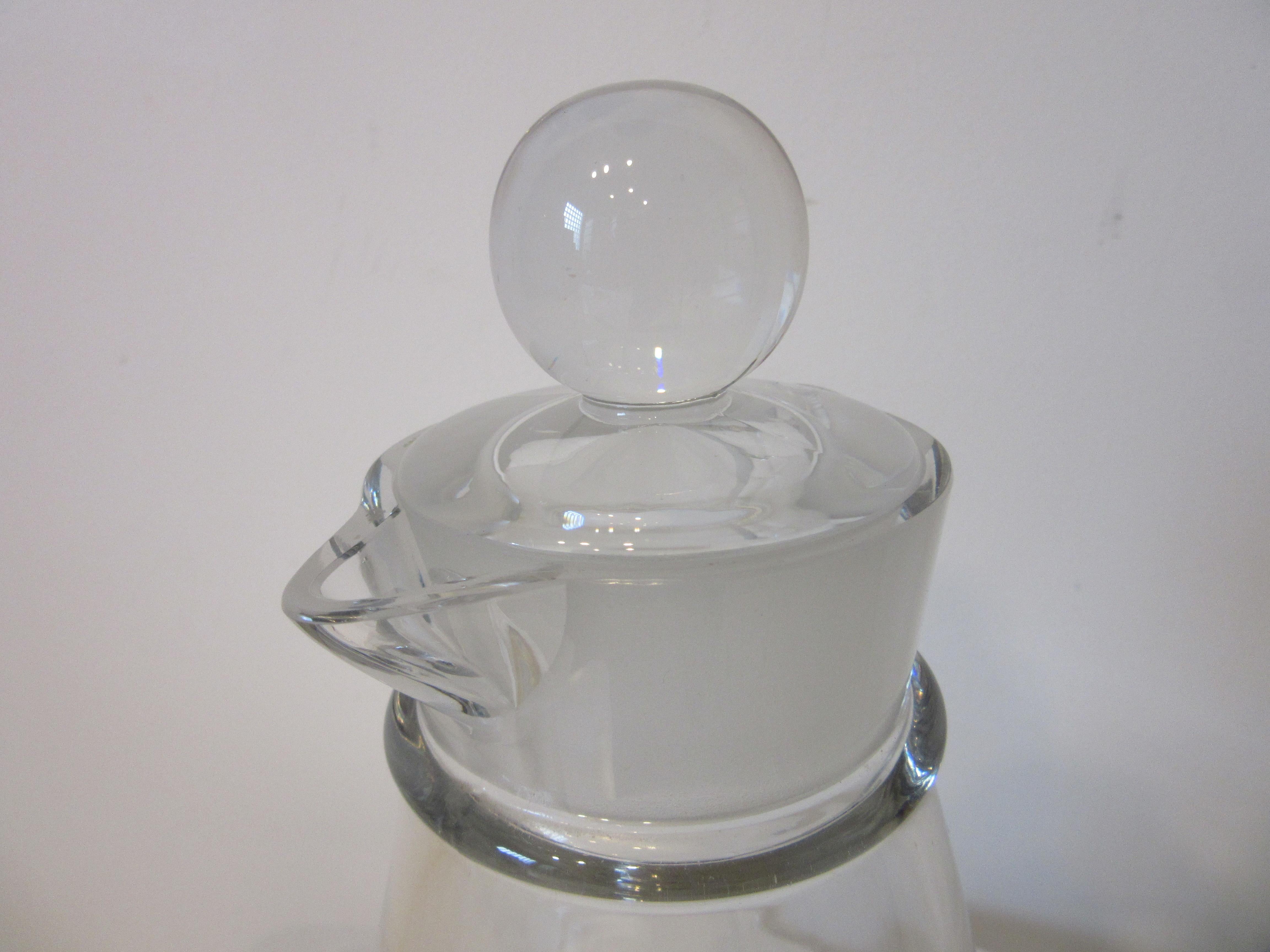 A very modern looking early heavy glass cocktail shaker with round ball top , frosted edge to the collar with two pour spout areas . The top has cut grooves to each end for shots or pours as pictured and a very well thought out design for the