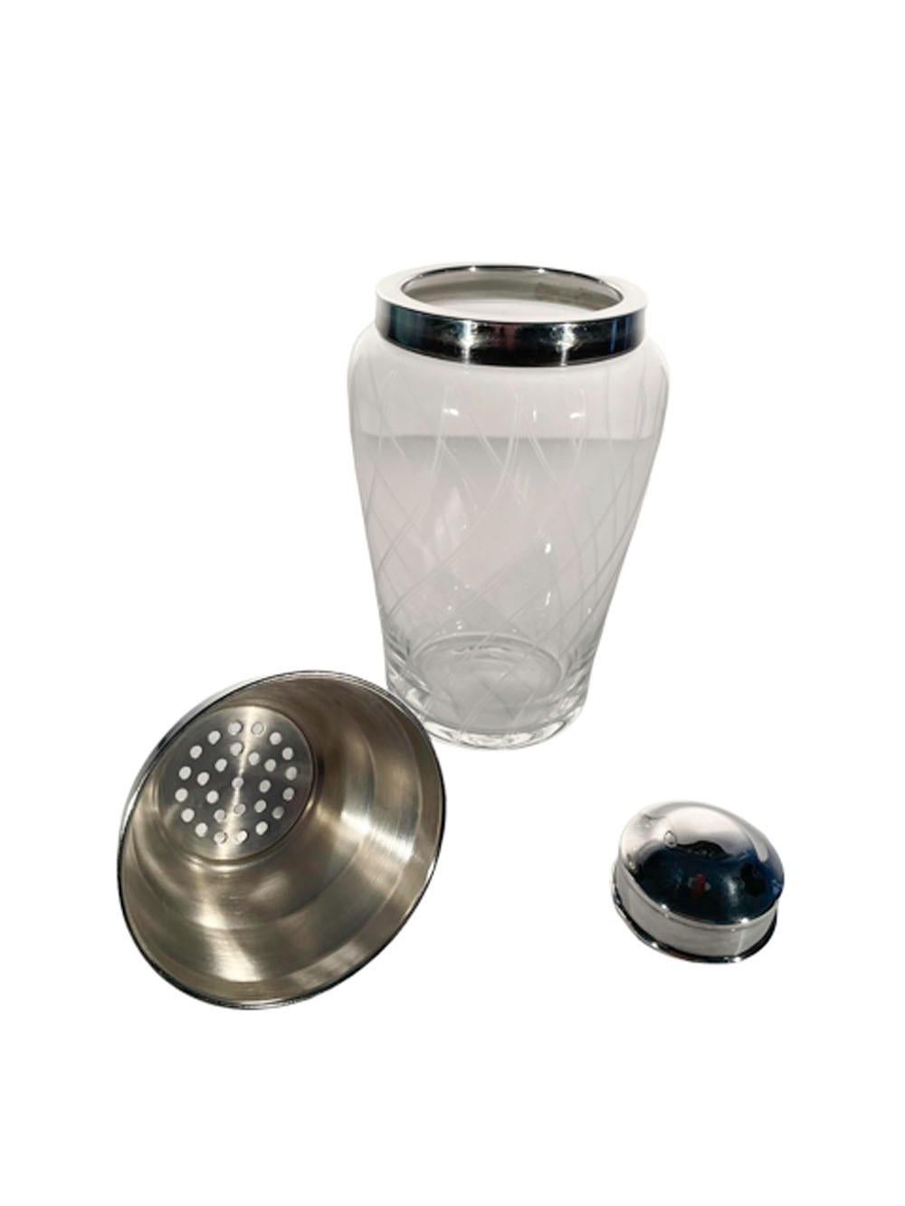 Early Twentieth Century cocktail shaker of clear glass with etched lines in a swirl pattern and a silver plate collar with silver plate cover.