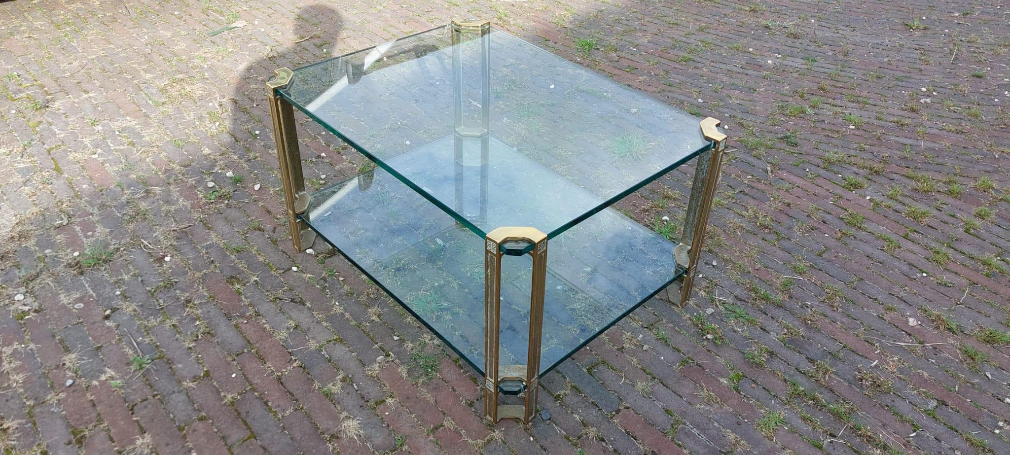 Retrocede a la década de 1970 con la exquisita Mesa baja de cristal Vintage, obra del renombrado diseñador húngaro Peter Ghyczy. Esta icónica mesa Modelo T24 tiene unas originales patas de bronce y latón, que sostienen dos gruesos estantes de
