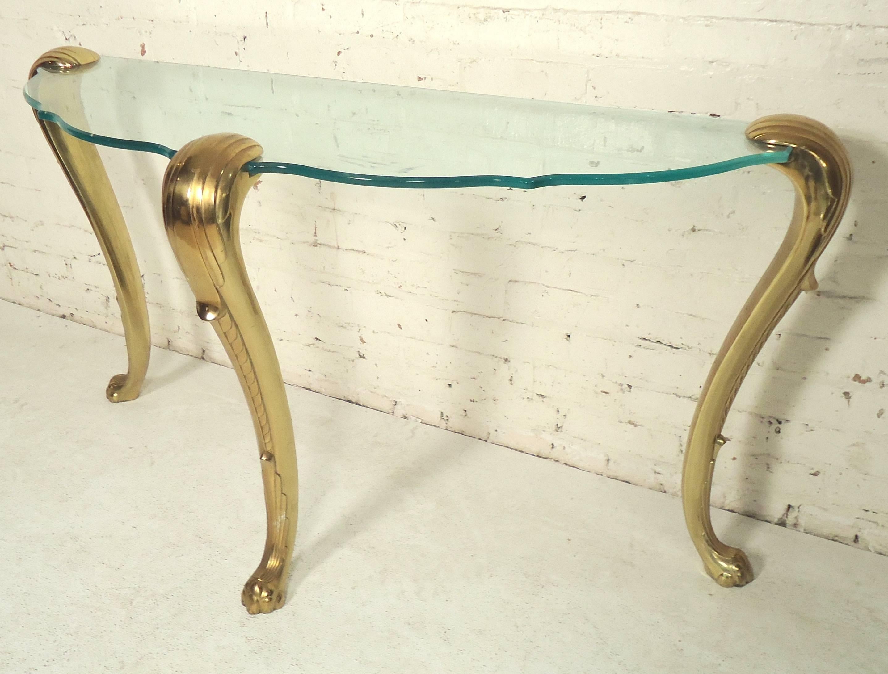 Beautiful hall table with beveled shaped glass, set on three heavy brass sculpted legs with claw feet.

(Please confirm item location - NY or NJ - with dealer)
