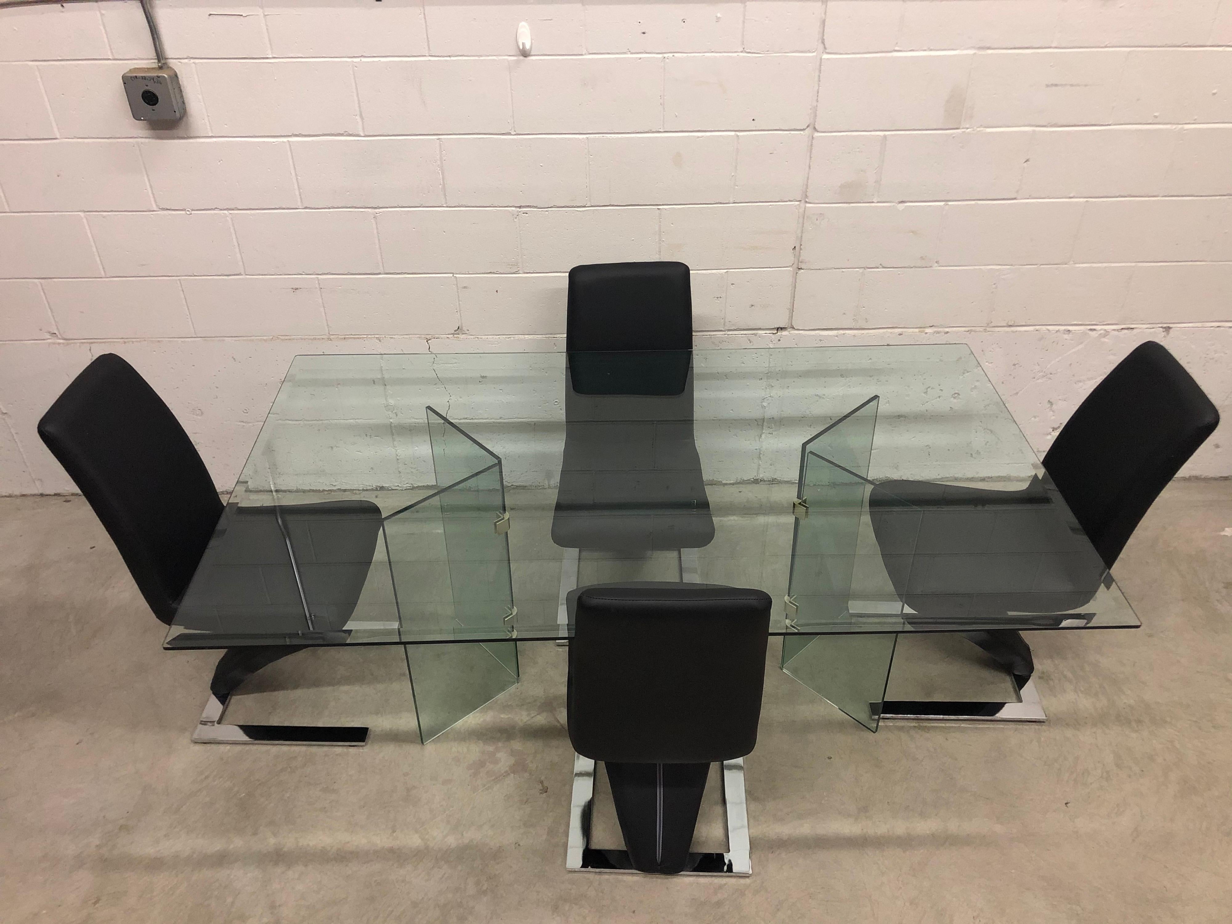 Vintage glass rectangular dining table with glass base and four zig zag vinyl Rinaldi-style dining chairs with chrome steel bases. The chairs measure 17” L x 18” W x 37.5” H, the seat is 19” H. The chairs are in excellent condition. The table has