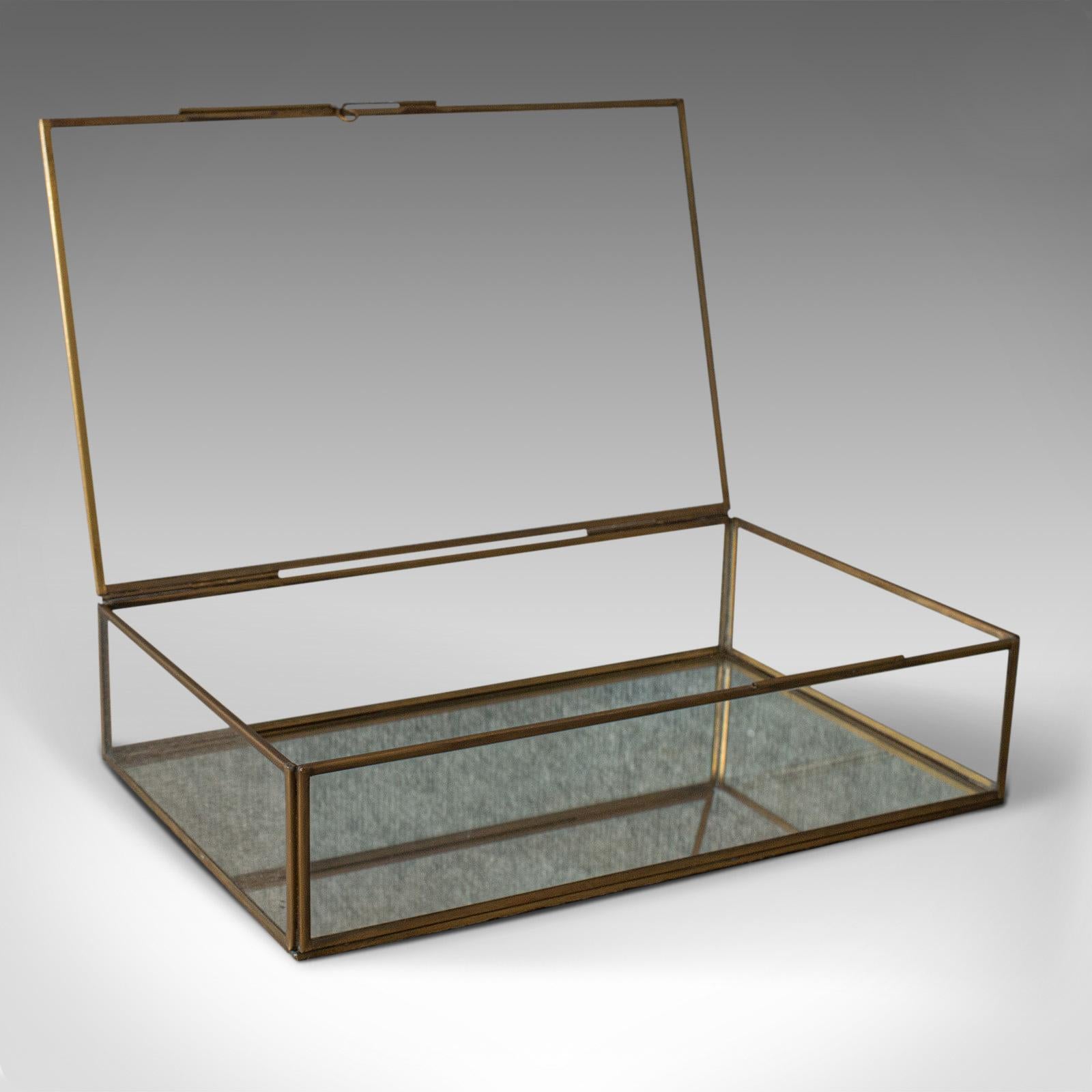 This is a vintage glass display case with mirror bottom. An English, brass showcase, dating to the late 20th century, circa 1980.

Attractive, bright glass showcase
Displays a desirable aged patina
Brass frame shows appealing golden