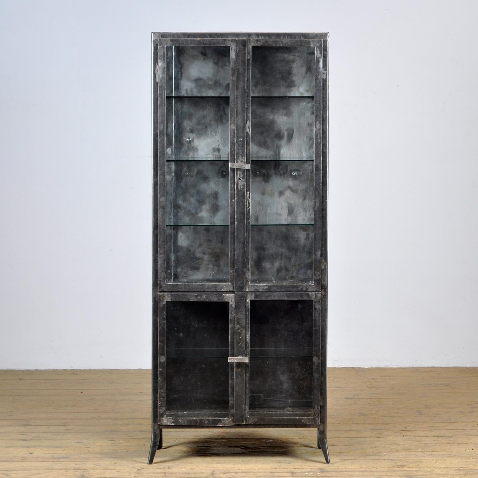  Medicine cabinet made of iron and glass. The cabinet is from the 1950s and was produced in Hungary. The cabinet is stripped down to the metal and finished with a transparent lacquer. The cabinet comes with 4 glass shelves. 