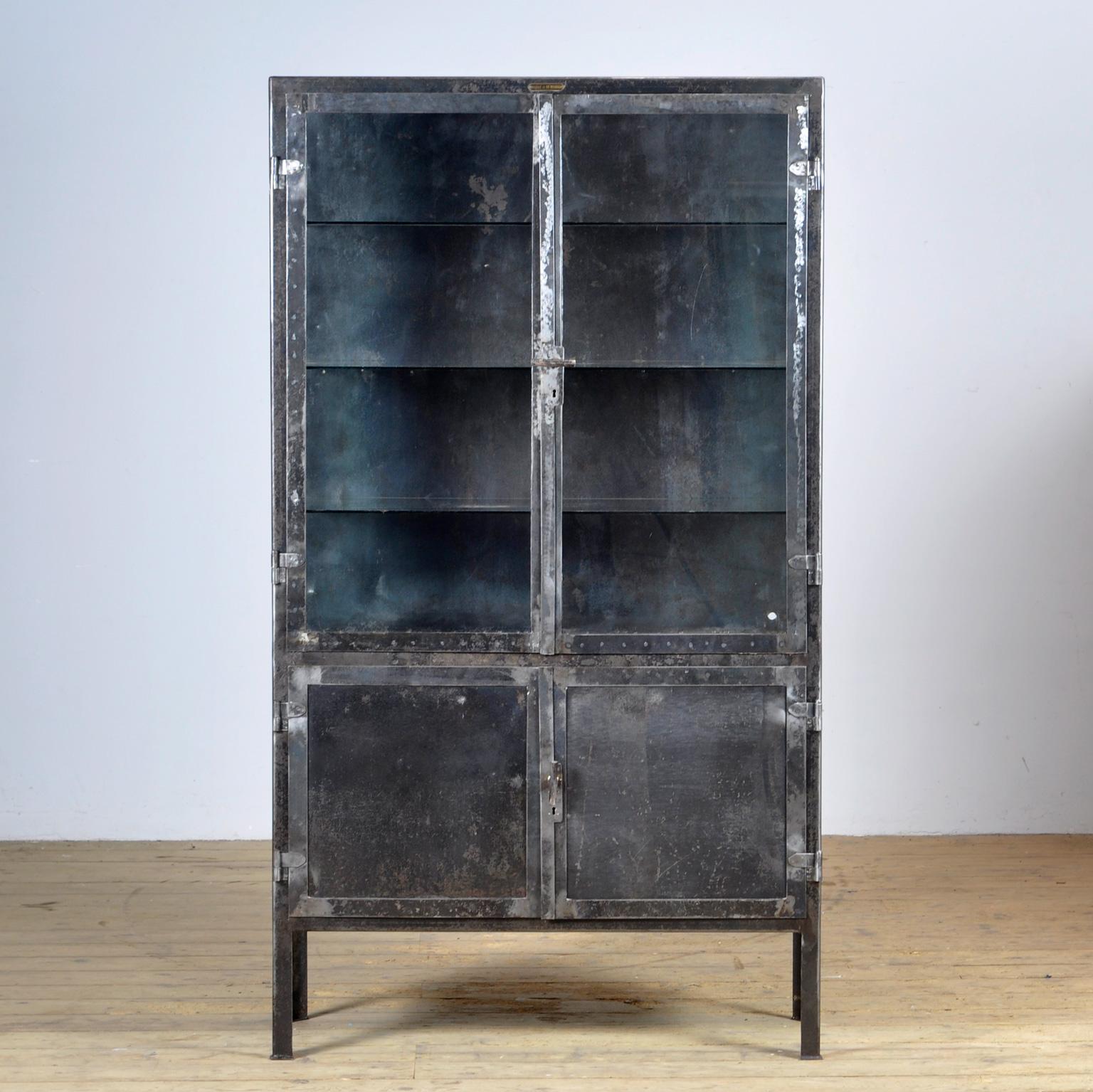  Medicine cabinet made of iron and glass. The cabinet is from the 1950s and was produced in Hungary. The cabinet is stripped down to the metal and treated for rust. The cabinet comes with 3 glass shelves. The space between the shelves is 25 cm