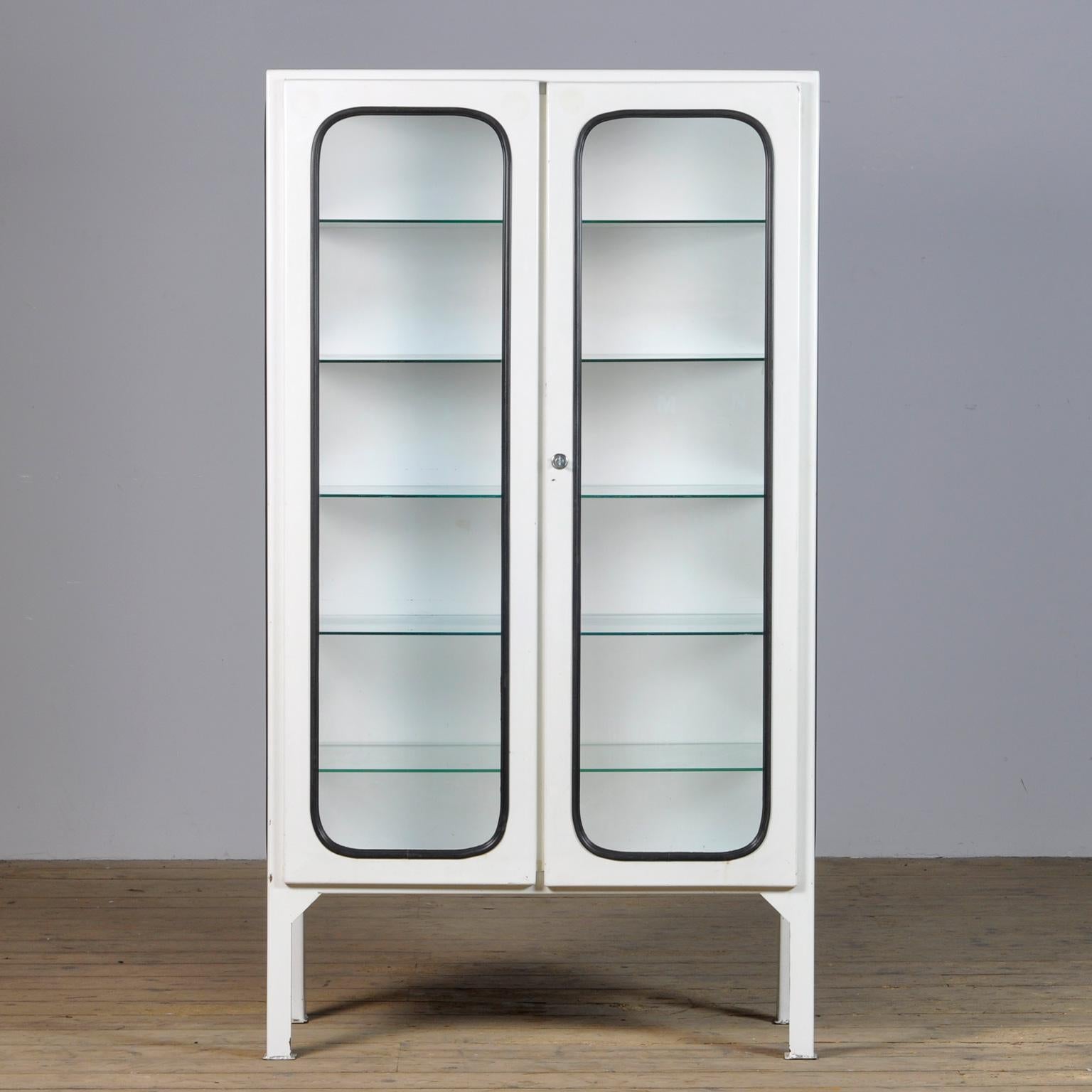 This medical cabinet was designed in the 1970s and was produced circa 1975 in hungary. It has been used in a hostital in Budapest were it was used to store medical equipment. It is made from iron and glass, and the glass is held by a black rubber