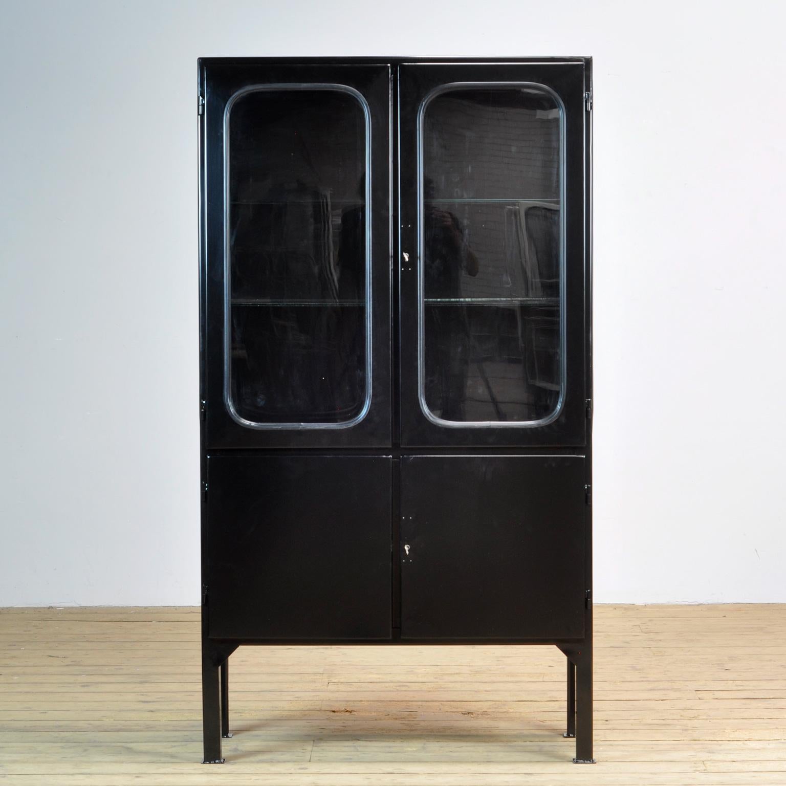 This medicine cabinet was designed in the 1970s and was produced circa 1975 in hungary. It has been sandblasted and powder coated in black. It is made from iron and glass. The glass is held by (new) black rubber stripa. The cabinet features two