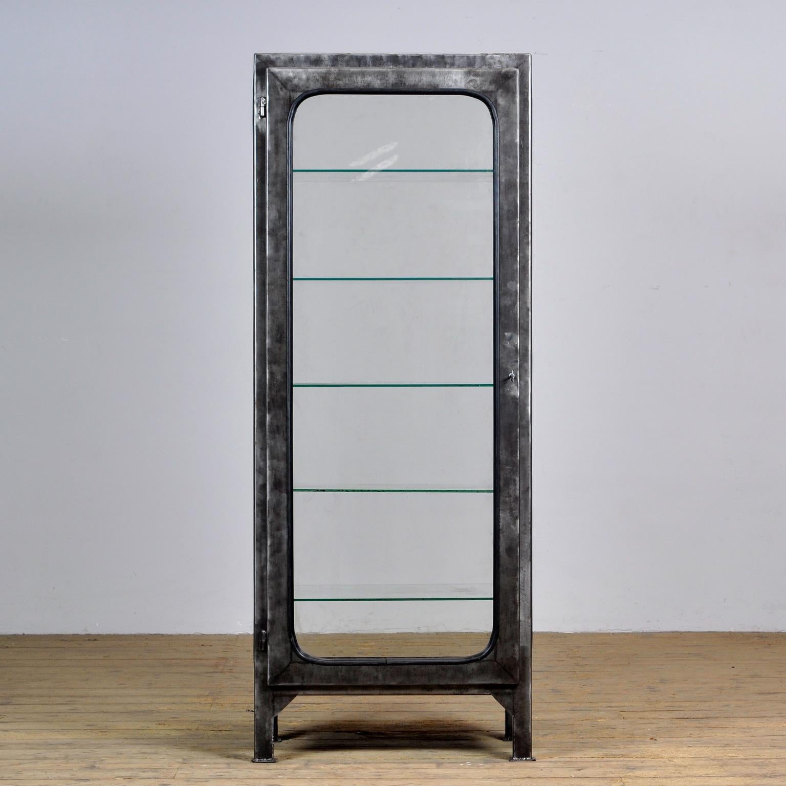 This medical cabinet was designed in the 1970s and was produced circa 1975 in Hungary. It is made from iron and glass, which is held by a black rubber strip. With glass on all four sides. The item has been stripped from its paint and finished with a