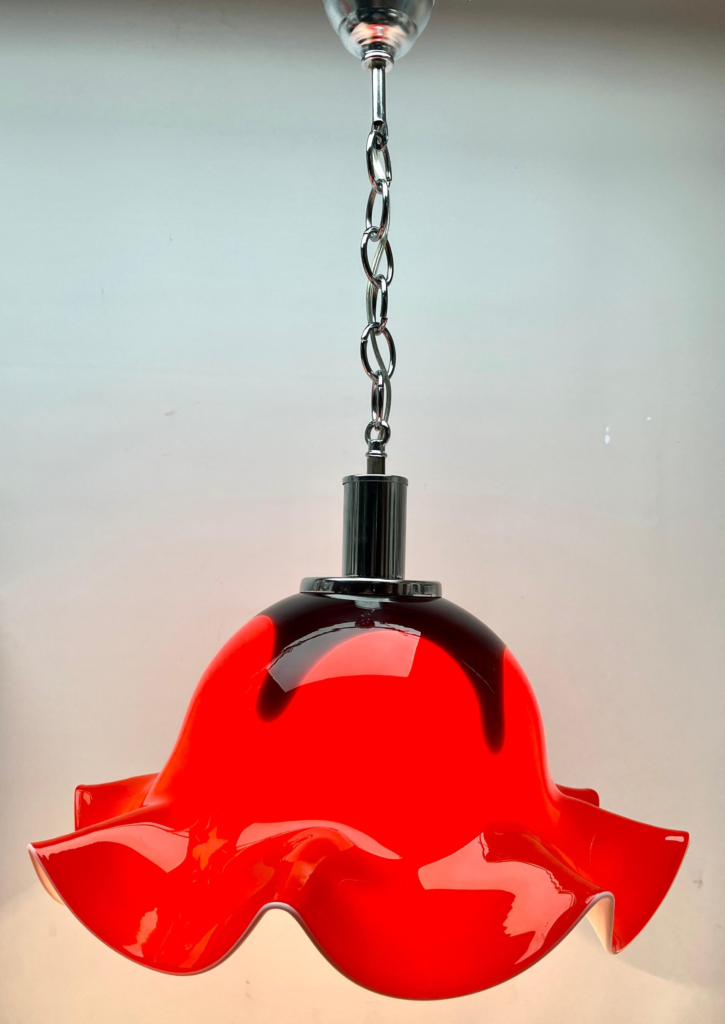 Vintage pendant light Murano. This central pendant light is crafted from heavy hand-blown glass with dramatic swirling clouds of red and black creating a warm feel. 

Photography fails to capture the simple elegant illumination provided by this