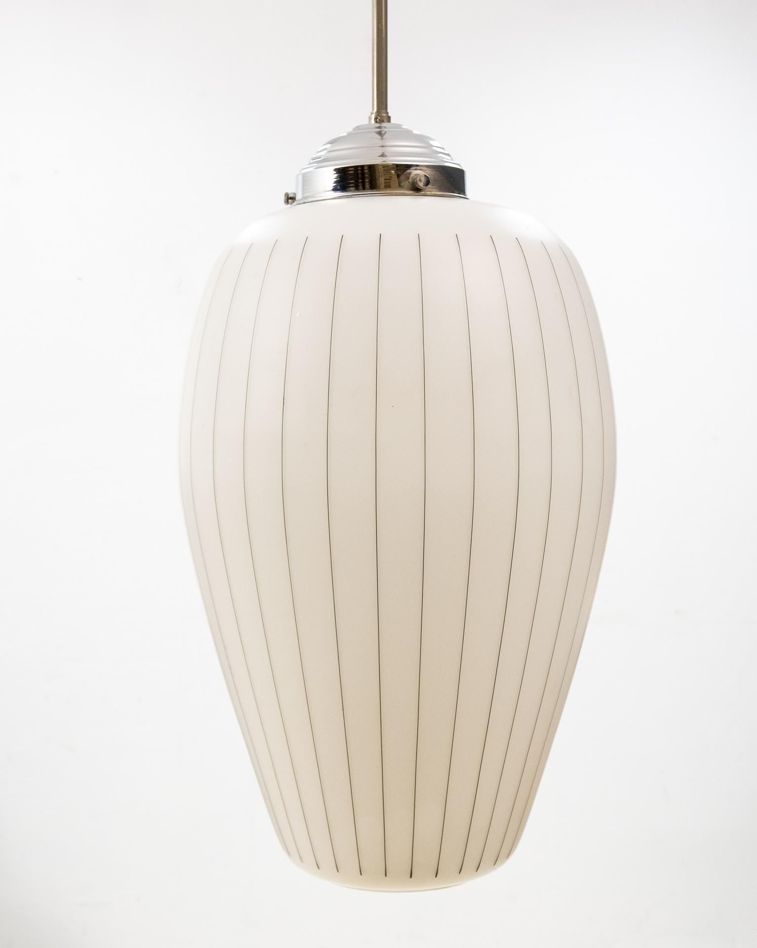 Very nice vintage pendant lamp. Chrome base, comes with an opaline glass shade.
With a tin black striping.